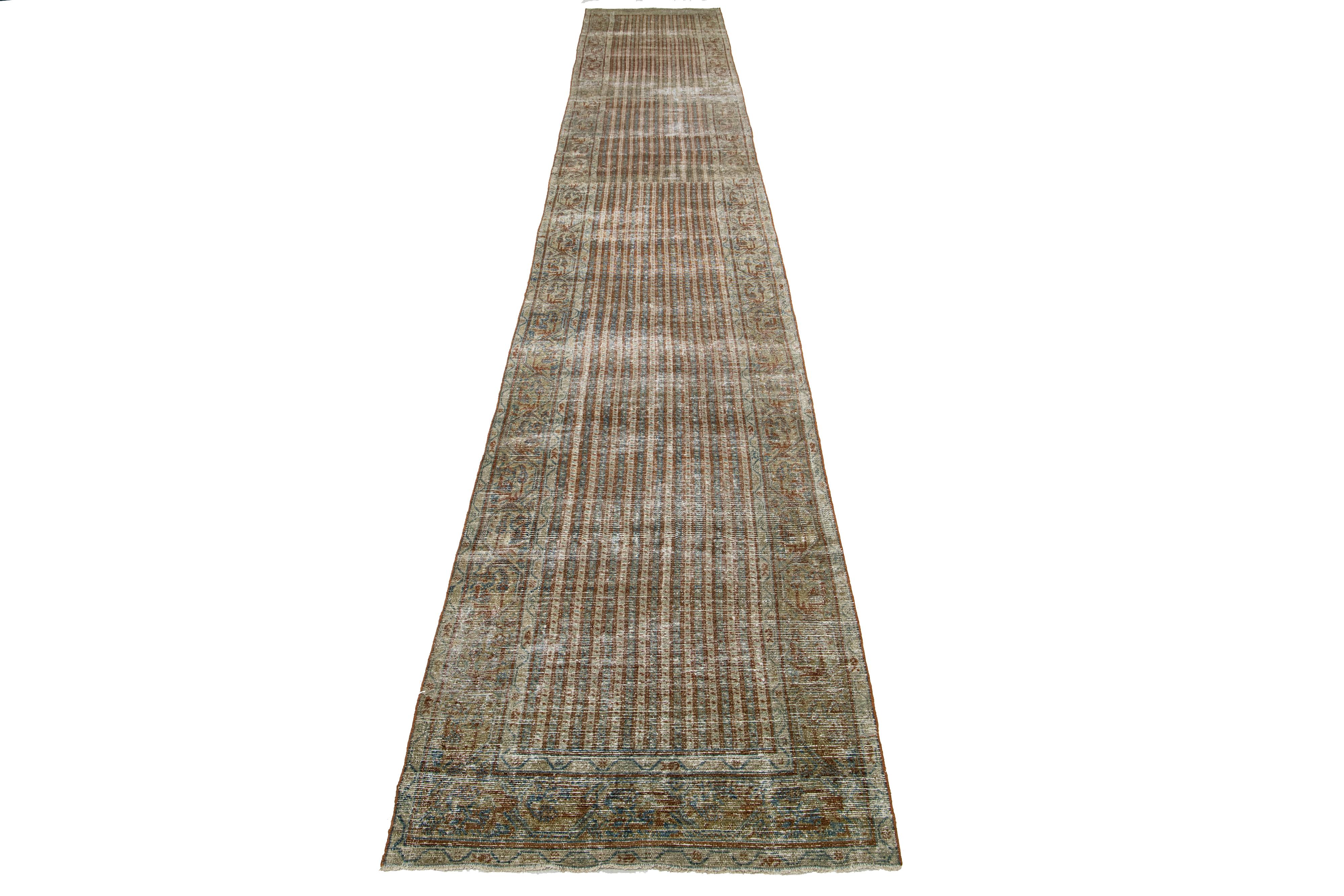 This long Persian Malayer wool rug possesses an antique allure. It showcases hand-knotted wool in a blue field. The striped pattern is embellished with copper and light brown accents.

This rug measures 3'2