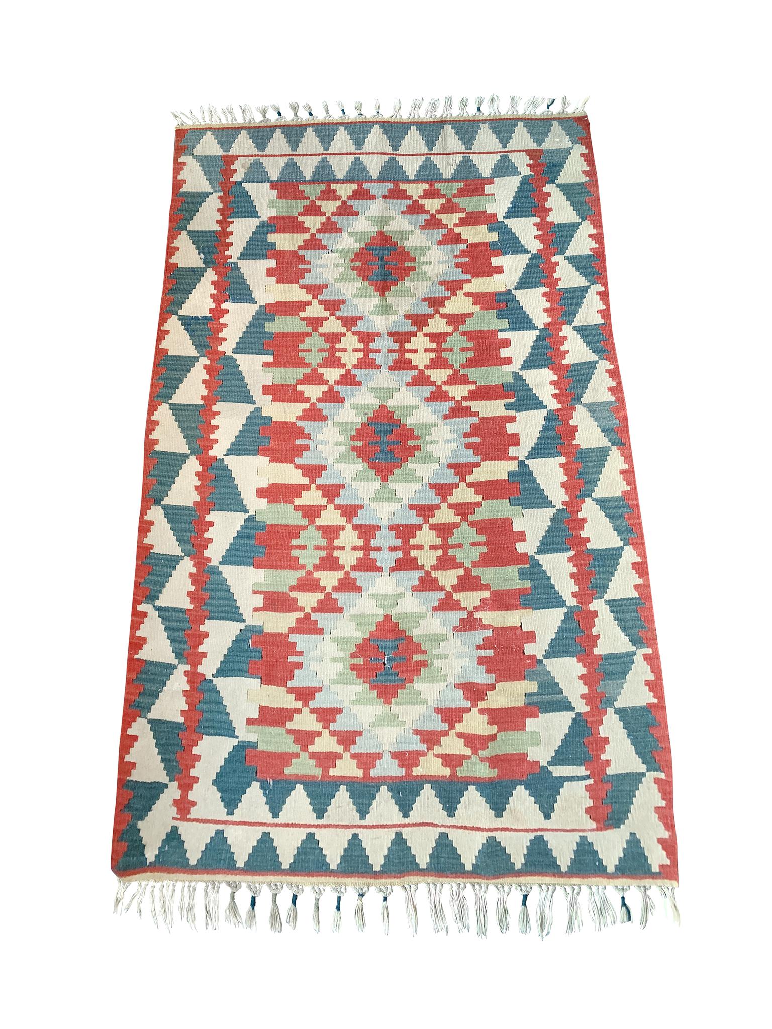 Navajo rug, handwoven in the 20th Century. With a palette of teal blue, red, pale green, light yellow, and ivory.

Dimensions:
5'9
