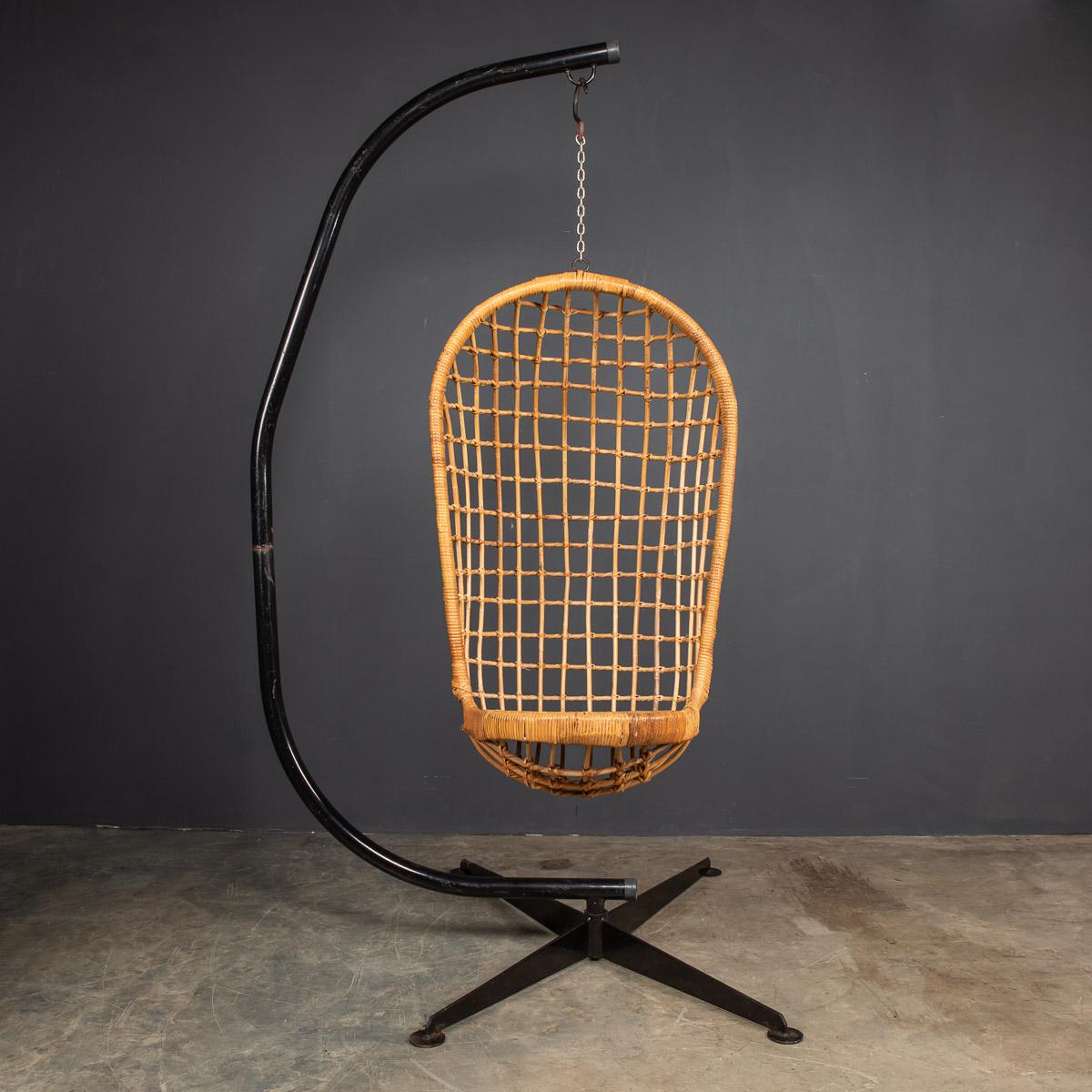 Chaise suspendue iconique du 20e siècle en osier sur cadre d'acier d'origine, fabriquée dans les années 1970, avec assise tressée serrée et haut dossier à motifs carrés, suspendue sur son lourd cadre d'acier d'origine peint en