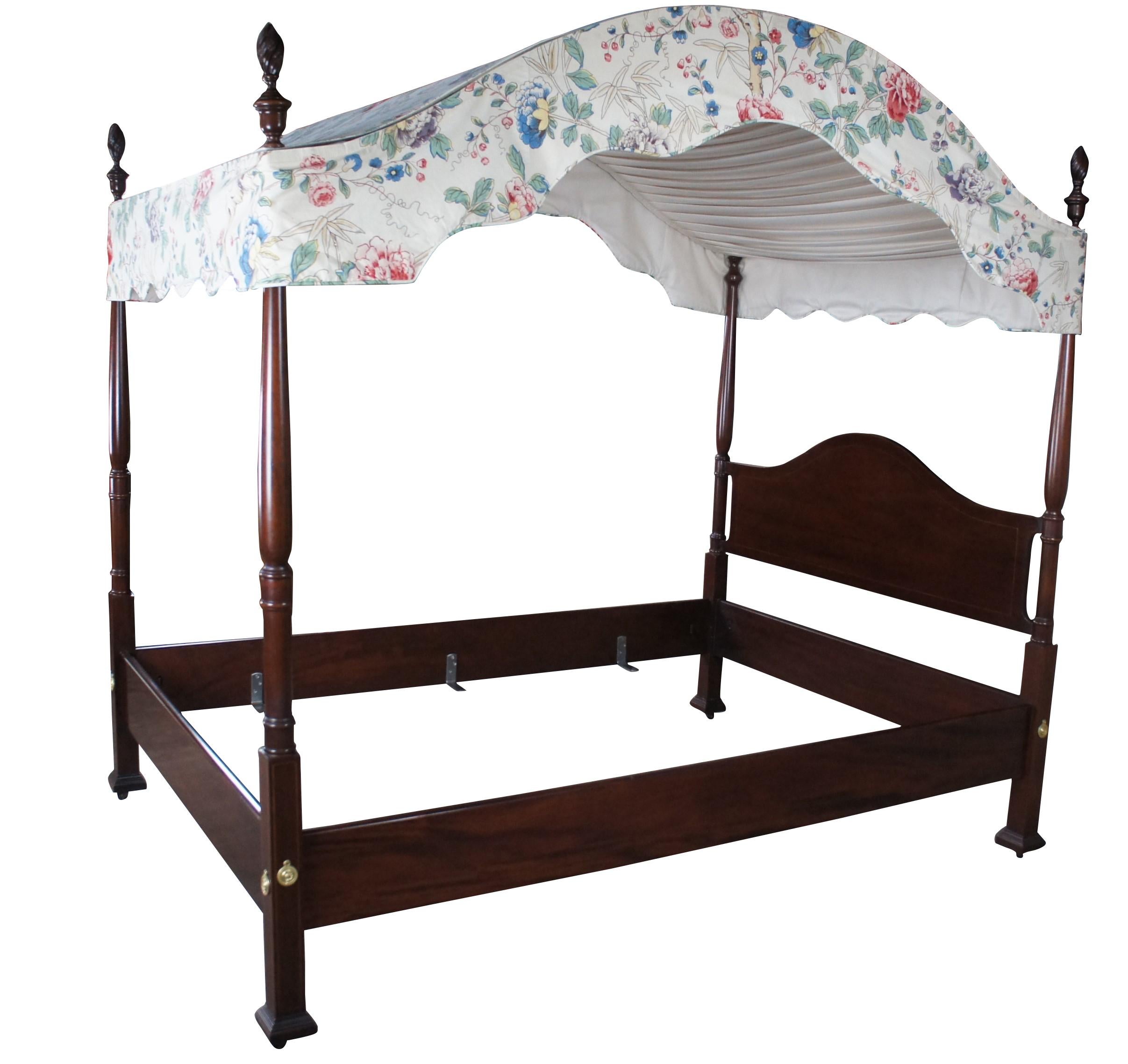 An impressive 20th Century inlaid mahogany four poster double size tester bed featuring Hepplewhite and colonial styling.  Features a camelback, through bolts and trophy cup turned and carved spire finials.  Includes a crewel style serpentine canopy