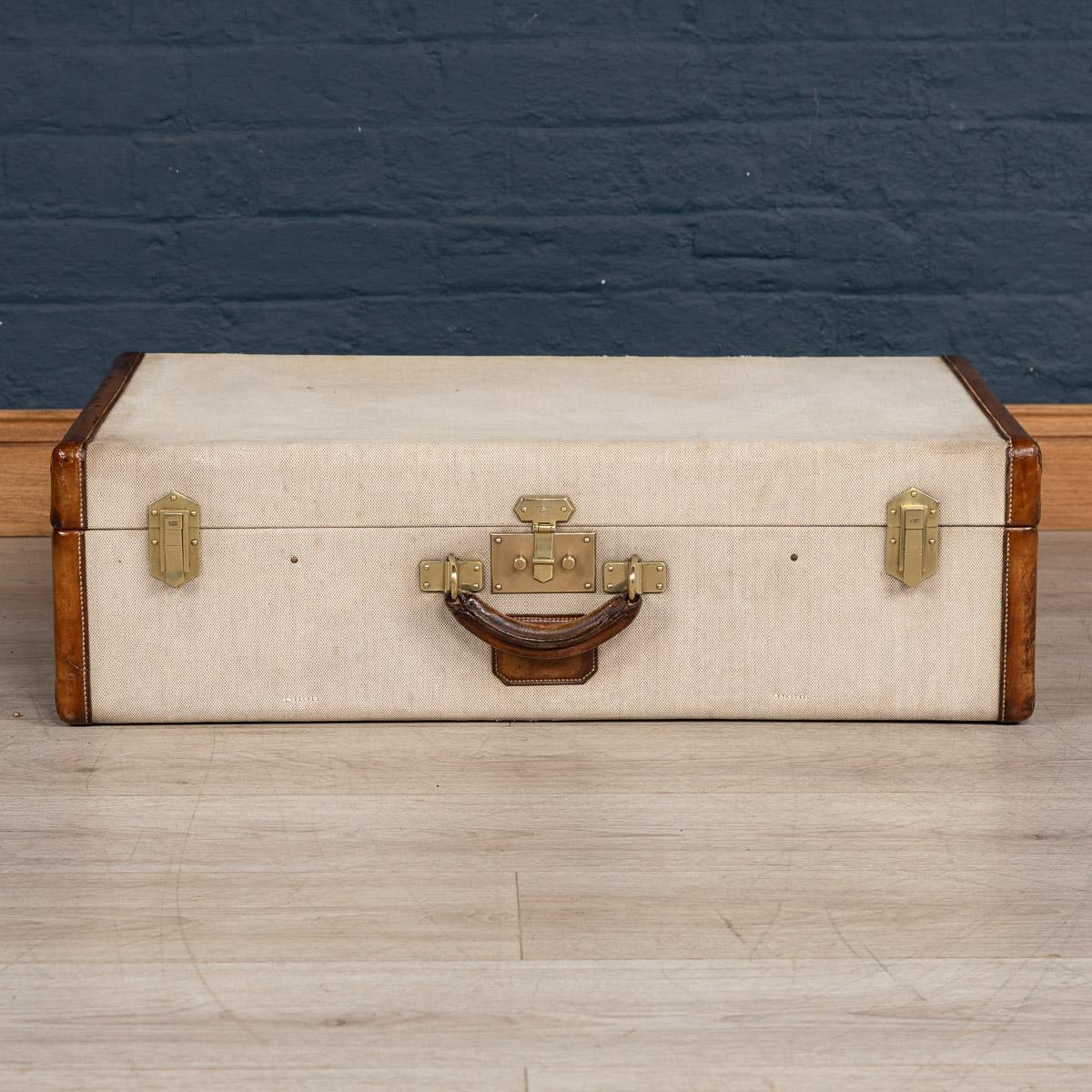 A very rare Hermès suitcase in canvas covering, leather reinforced edging with brass locks and side latches, made in France in the early part of the 20th century. A great addition to any collection and a fantastic item to have as part of a stack in