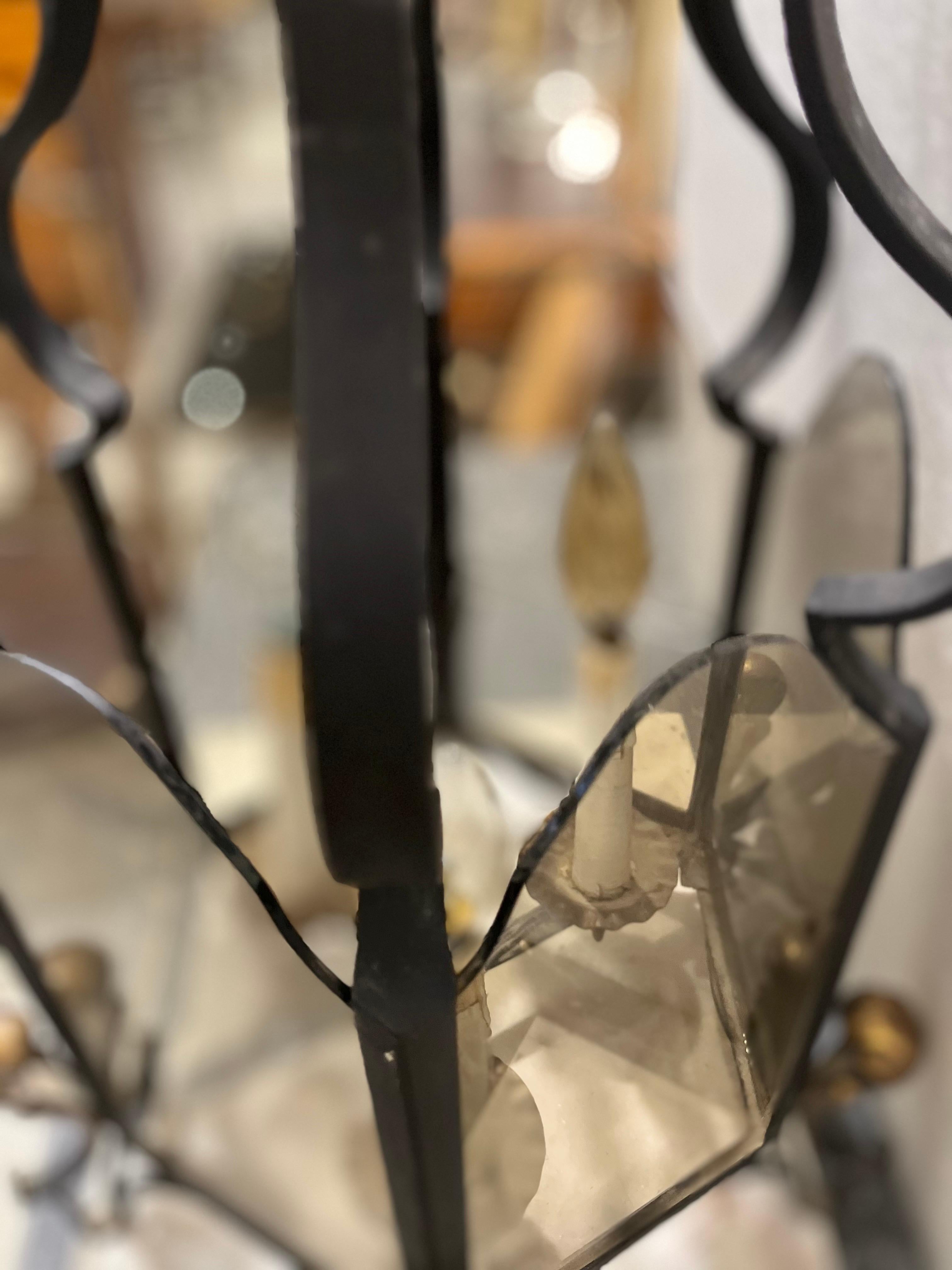 A hexagonal shaped lantern in cast iron and gilded metal decoration, with six glass panels and three candle-shaped light points, the top in gilded metal.