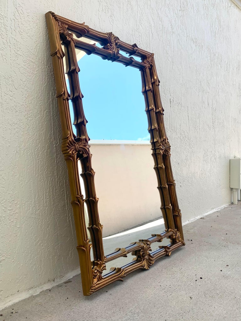 Stunning and large mid century carved wood mirror. Style inspired by Serge Roche, gold gilt with a double lined design. Dated to the 1970s. In good condition with some warm patina to the wood and age appropriate wear and use. 

Measures: 50”