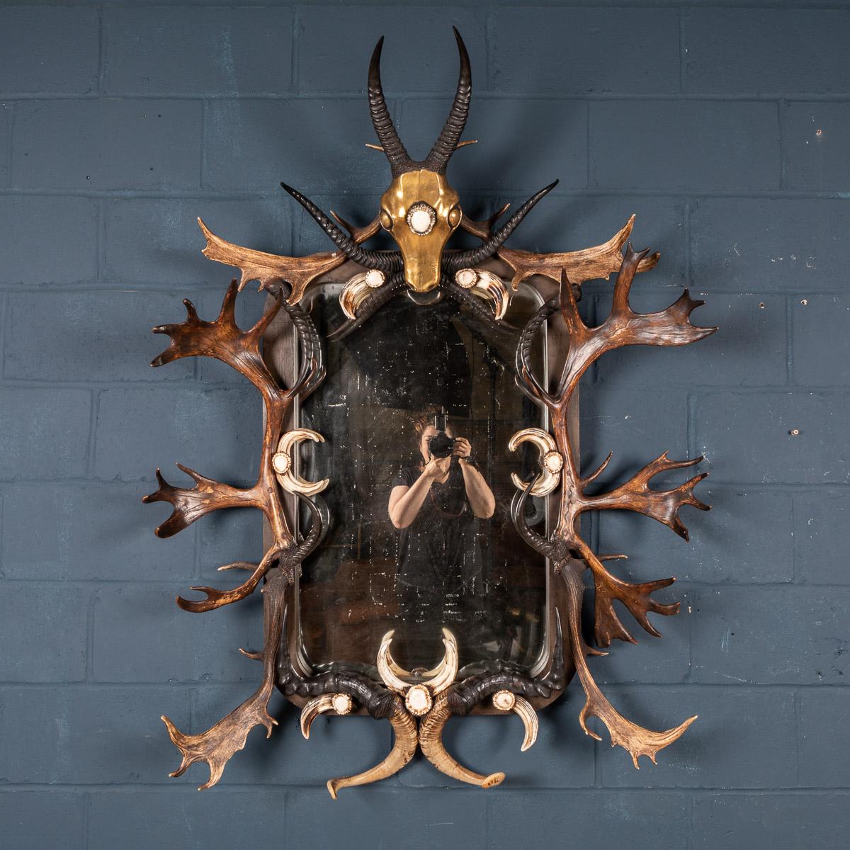 A very large rectangular mirror, the ebonised wood mounted with boars’ tusks, various types of horn, (including deer, ibex, mountain goat), and a brass antelope head with antler socket medallion. 

Condition
In Good Condition - wear consistent