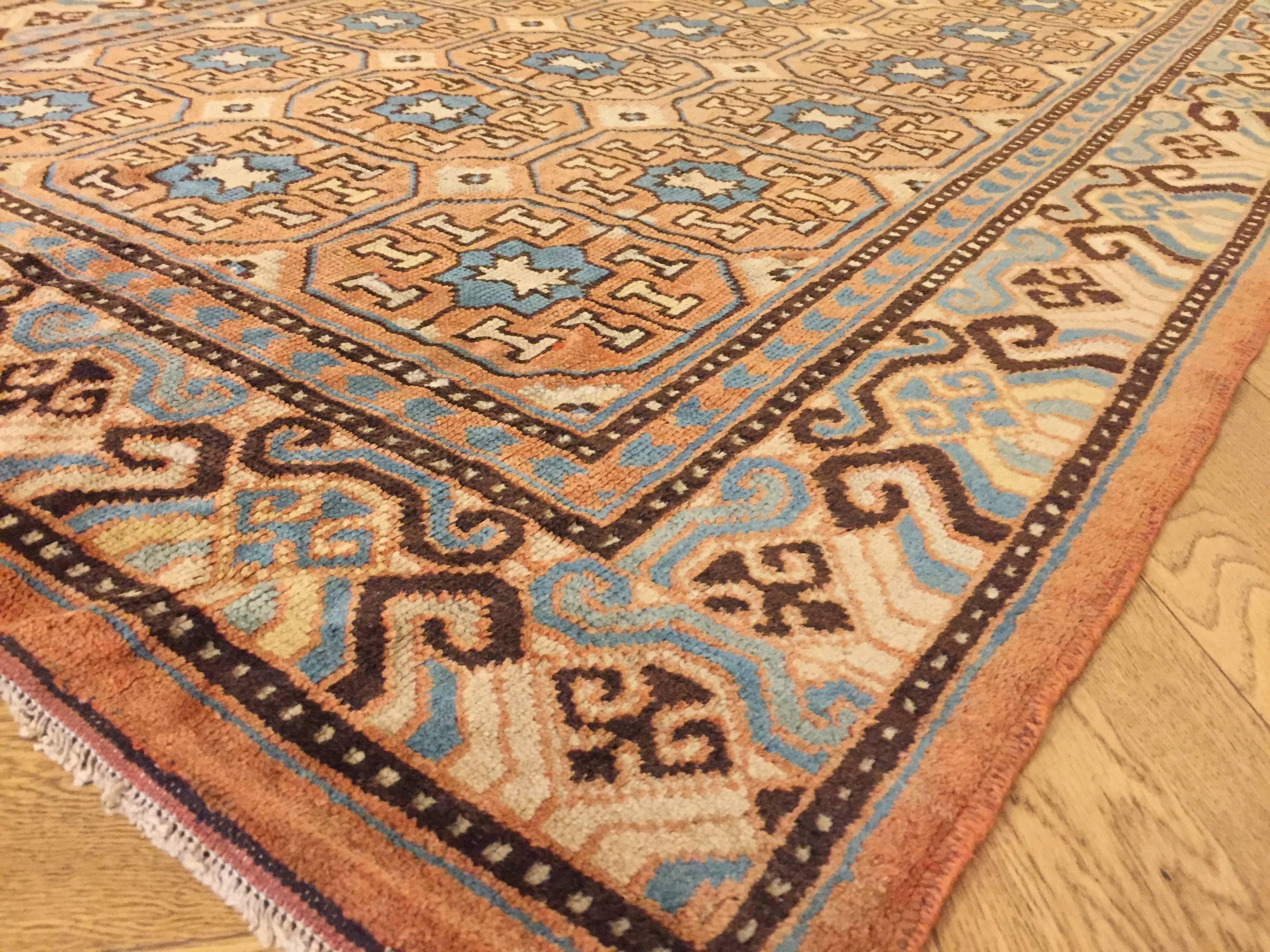 Wool 19th Century Brown and Blue Stylized Rosette Gul Chinese Khotan Rug, circa 1870s For Sale
