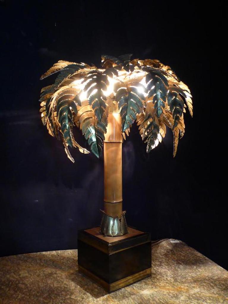 20th century French table lamp model palm tree house Jansen from the 1970s. 
The base is made of bamboo and the foliage in cut and openwork brass.
The wooden planter is covered with black laminate and edged with polished brass angles. 
Traces of