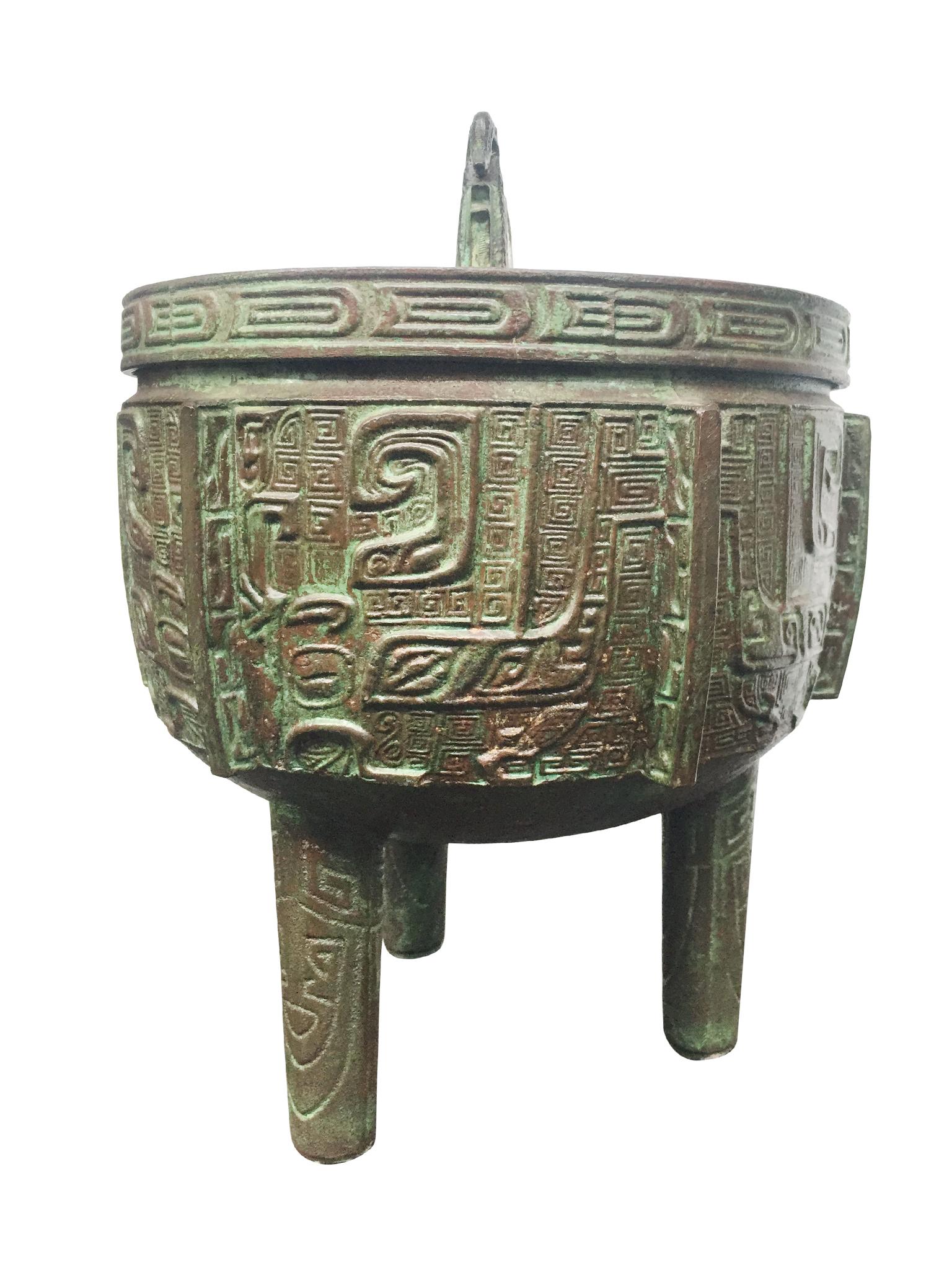 This 20th century ice bucket is designed with a metal exterior in a faux bronze finish and intricate geometric engraving and embossing. The bucket was made in Taiwan and recalls the style of the eccentric designer James Mont. The interior of the