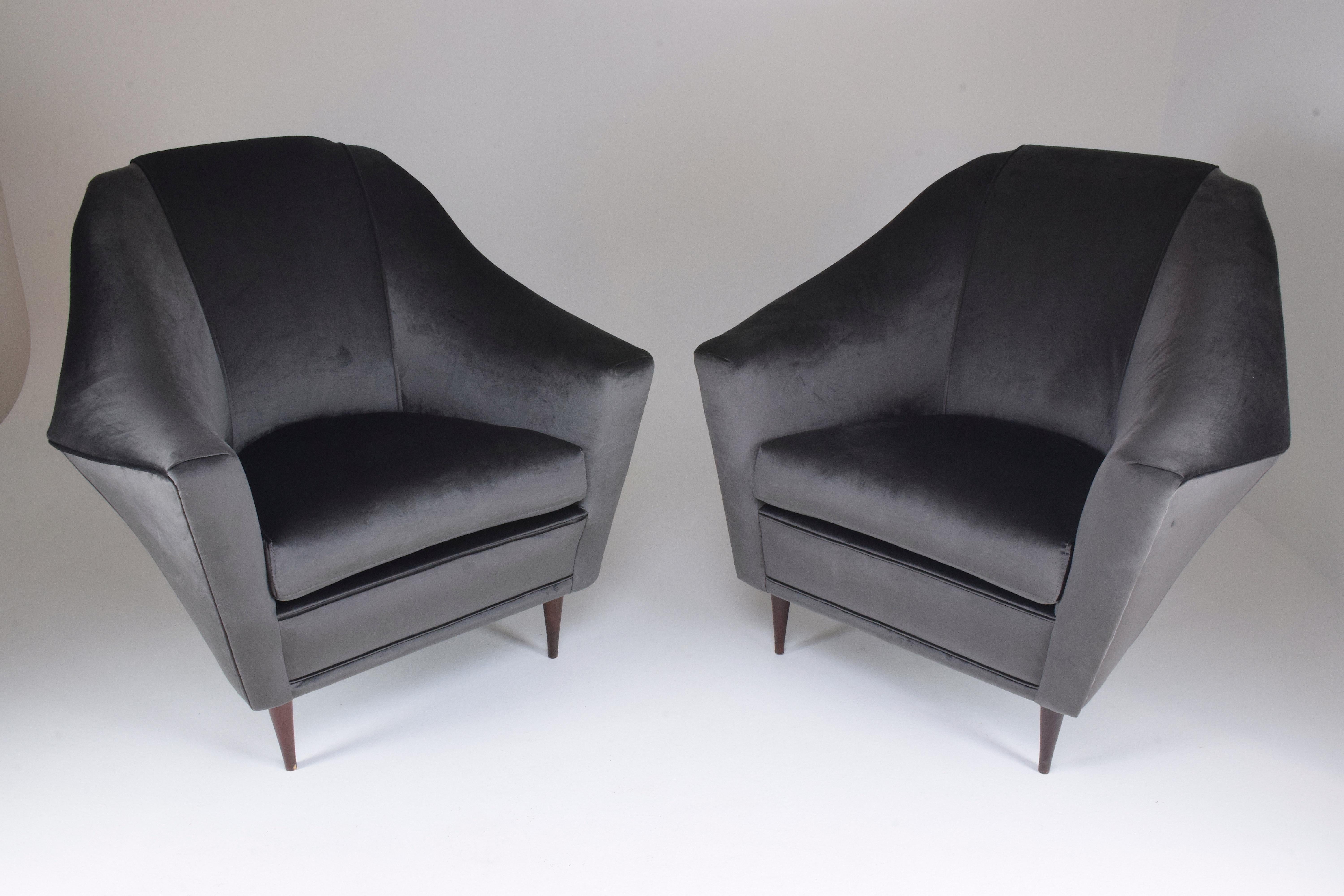 A rare pair of two Italian midcentury collectible armchairs or lounge chairs designed by Ico and Luisa Parisi for Ariberto Colombo at the beginning of the 1950s. The angular shape of the backrest and cone-shaped wooden feet are an Italian design