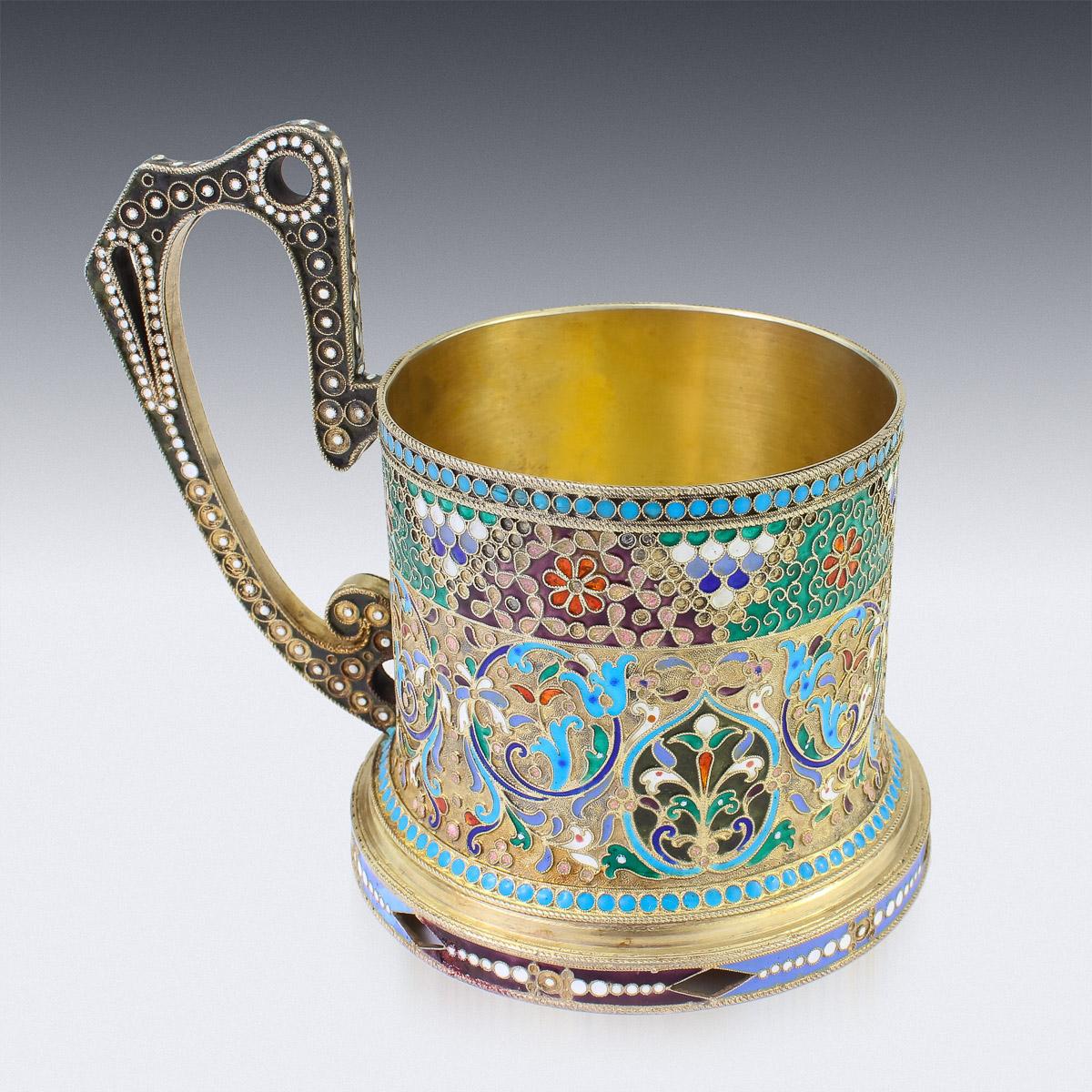 Antique 20th century Imperial Russian solid silver-gilt & cloisonne enamel tea glass holder, circular with upright scroll handle, plain top rim and spreading foot, body profusely decorated with floral scrolls in vary-coloured cloisonné enamel within