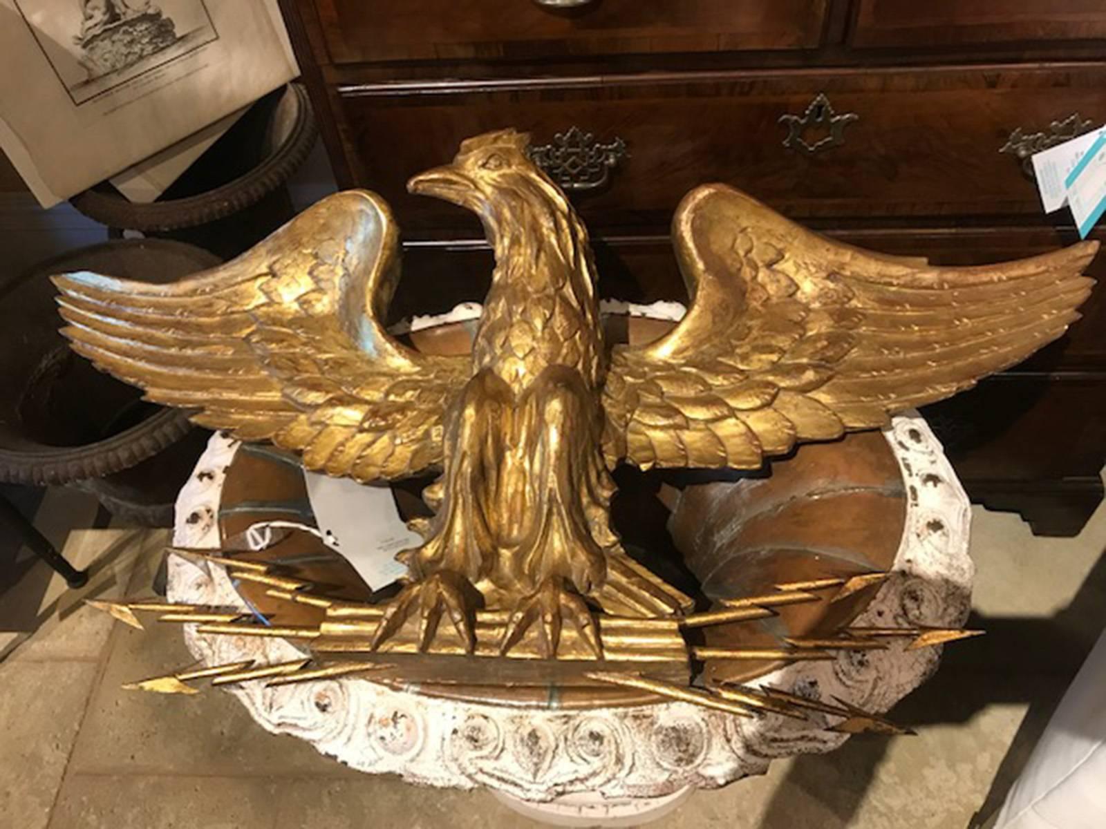 20th century impressive giltwood eagle holding metal arrows.