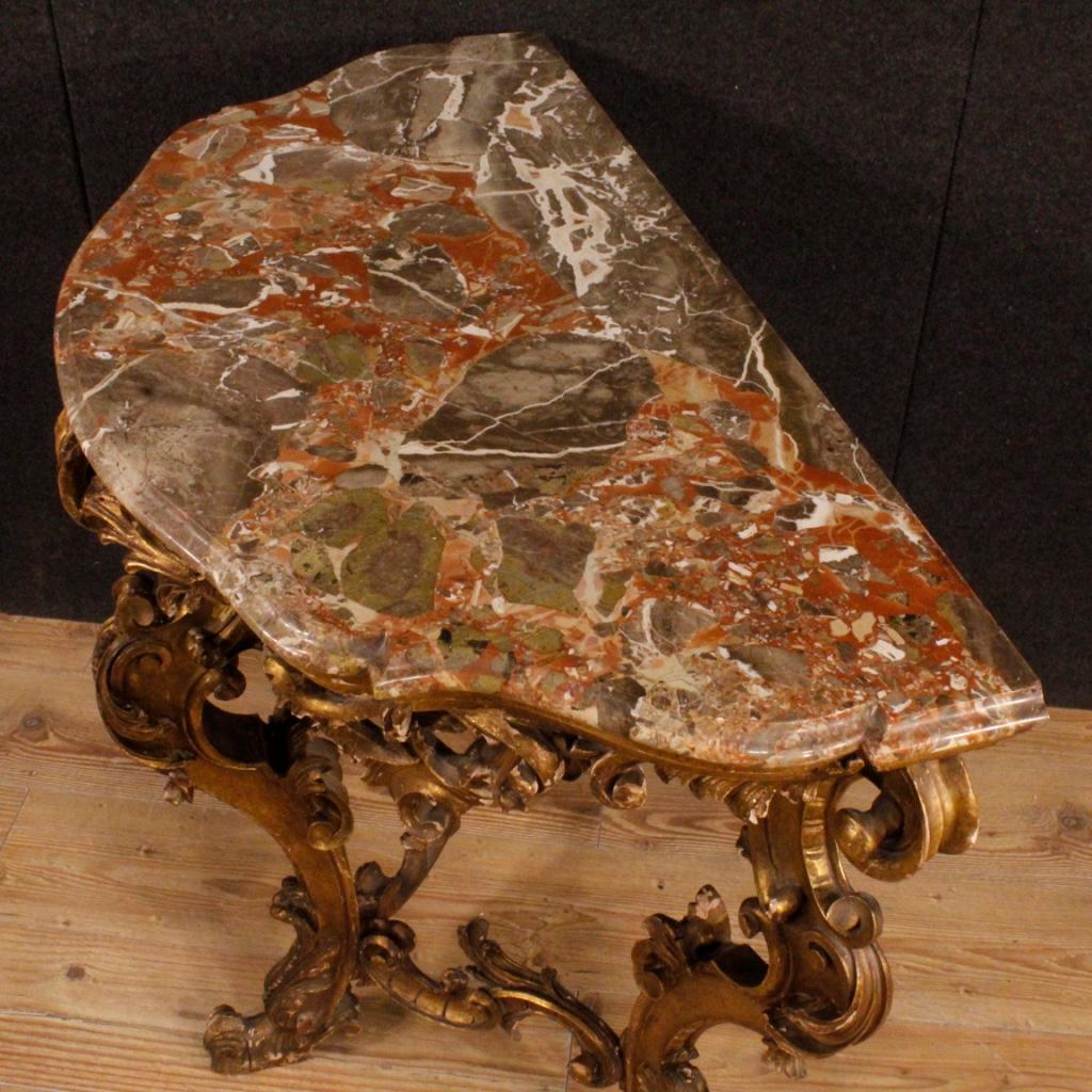 Italian console with marble from the first half of the 20th century. Furniture in Louis XV style in finely carved and gilded wood of good quality resting on three-feet. Console with marble top of good measure and service. Marble that has undergone a