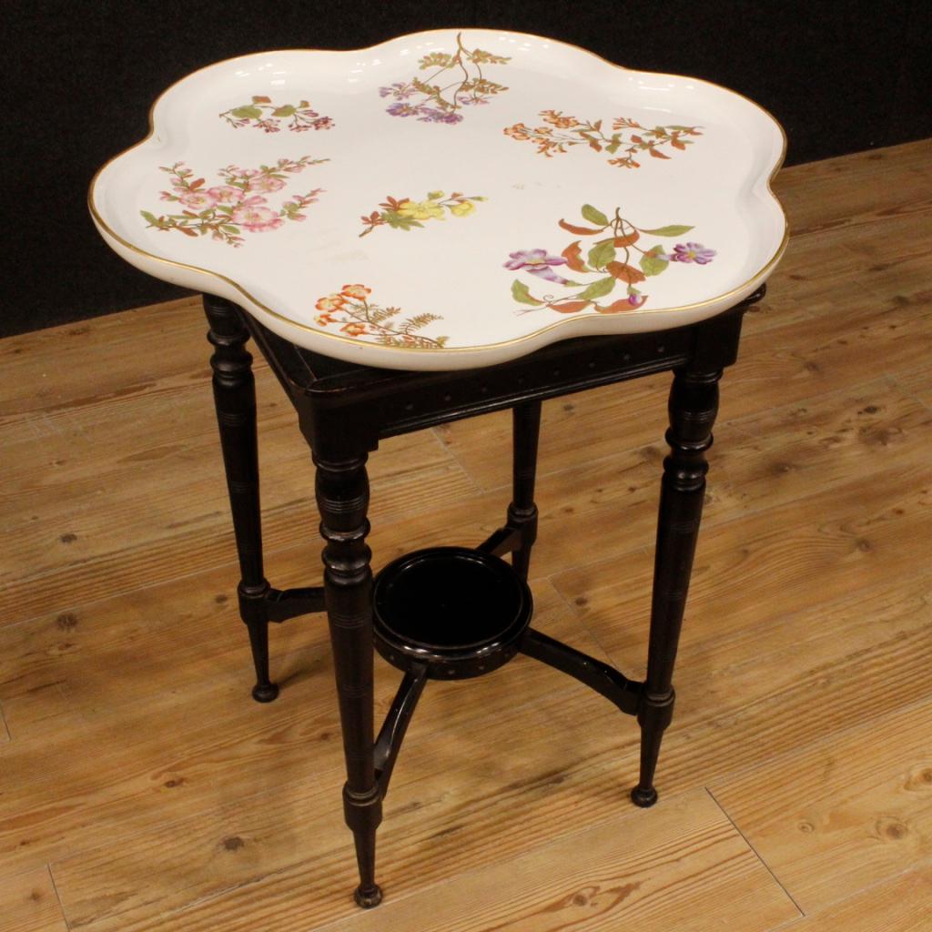English side table from 20th century. Furniture in ebonized oak with glazed and painted ceramic top with floral decorations of excellent quality. Tea table difficult to find, for antique dealers and interior designers. Wood that has some small drops