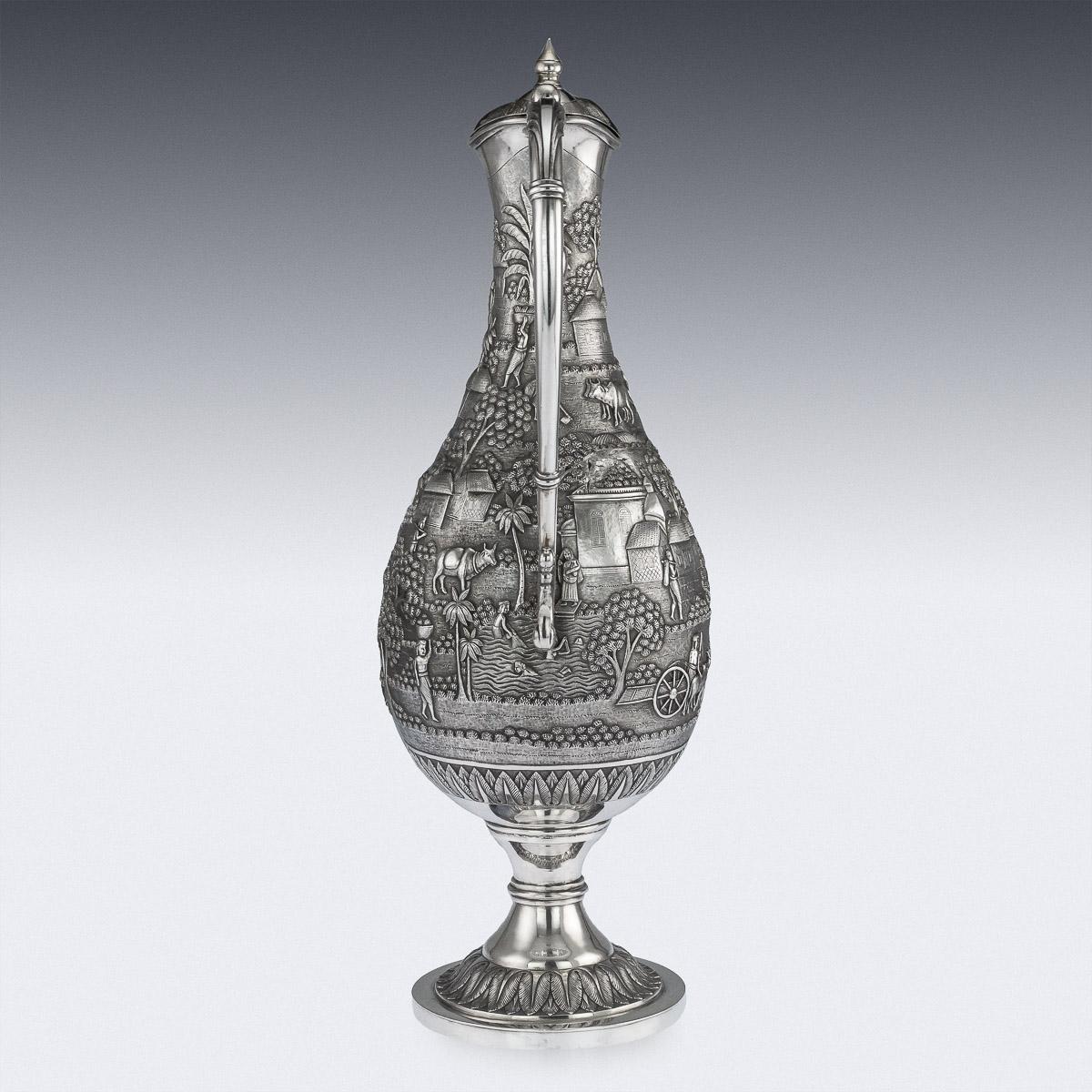 Antique early 20th century Indian monumental solid silver ewer, of traditional form, repousse decoration consisting of dense rural scenes, including a herdsman watching his cattle, a peasant man carrying water, another driving an oxcart, carrying a