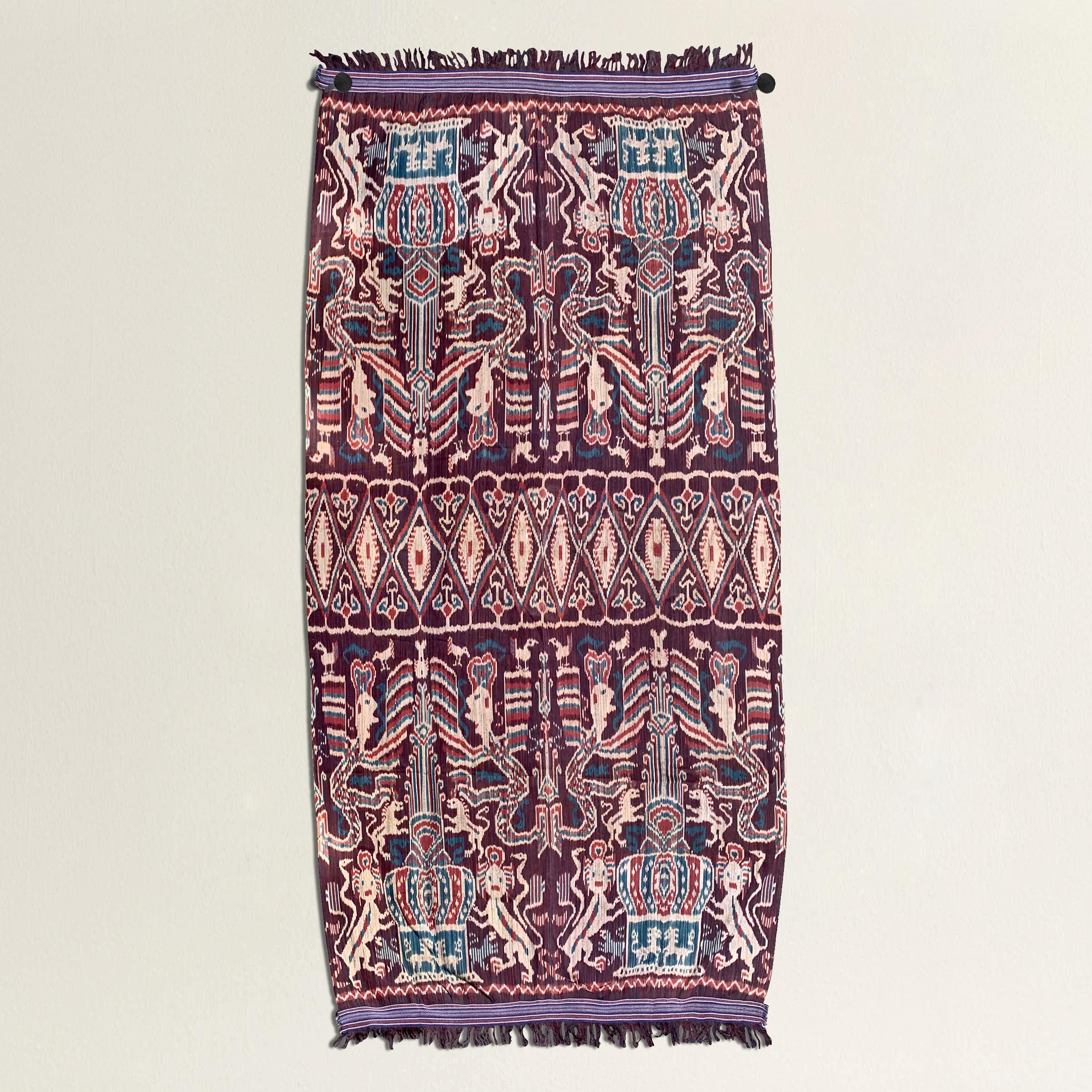 An incredible 20th century Indonesian hand-loomed ikat textile from the island of Sumba and depicting many lions, birds, and other mythological winged figures woven in beautiful vegetable dyed cotton. Textiles like these were historically worn by