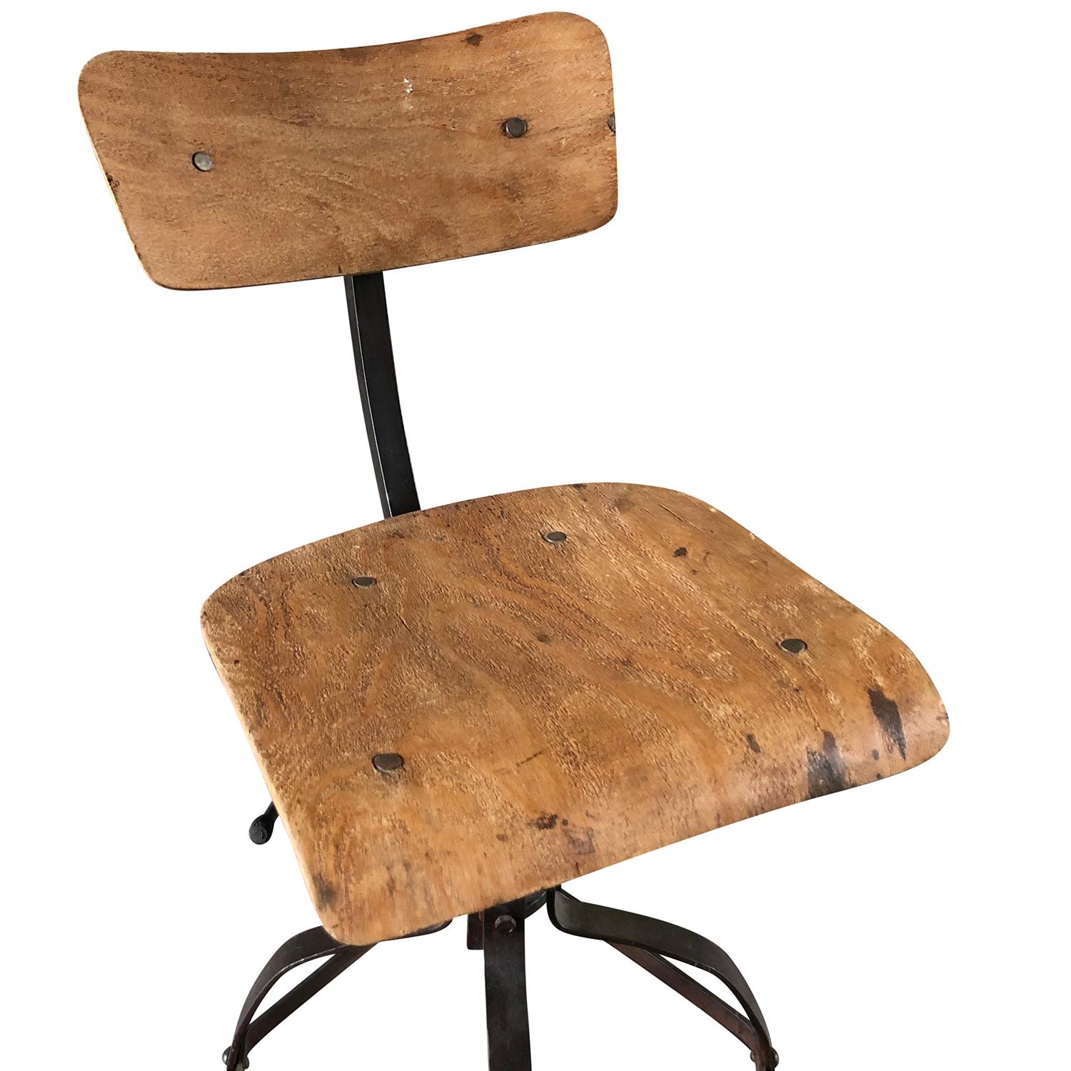 A light-brown, vintage French industrial iron workshop chair with metal framing and a wooden seat made of hand carved plywood, the seat height is adjustable. Designed by Henri Lieber and produced by Flambo, in good condition. Wear consistent with