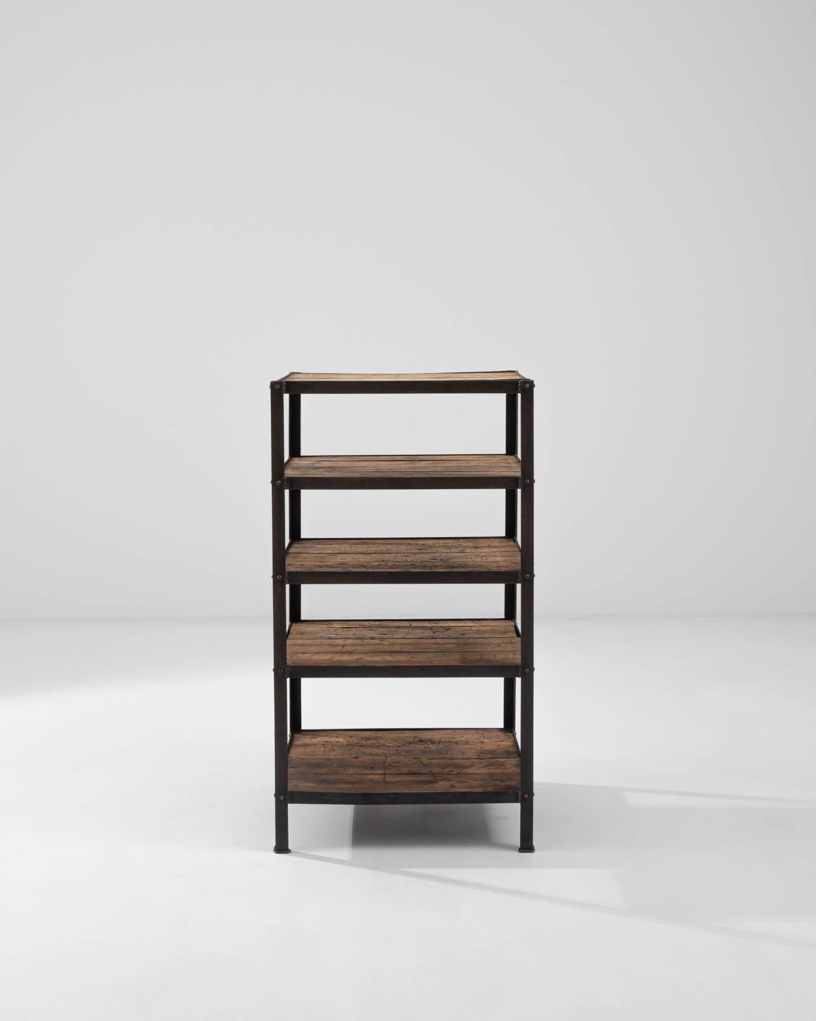 A wooden and metal shelf created in 20th century France. Industrial, yet surprisingly homey, this sturdy set of shelves emits an orderly and approachable aura. Forthright in its design, the five equally sized shelves offer a wealth of storage space.