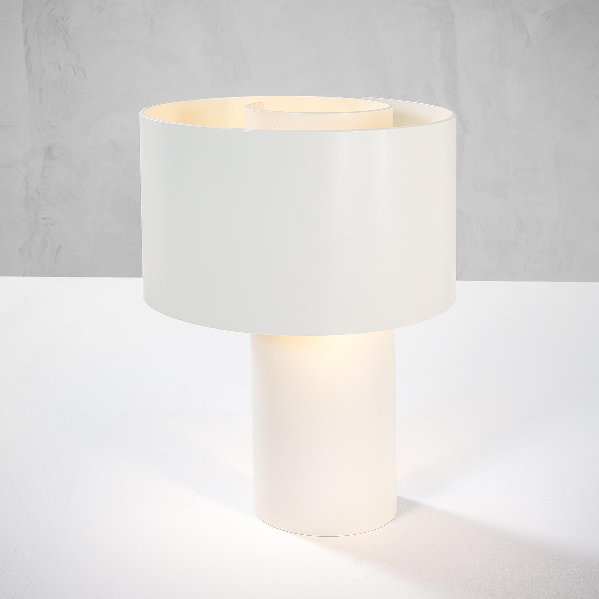 This table lamp was designed by Ingrid Hsalmarson in the 70s for New Lamp. It is entirely in white lacquered aluminum, made up of a simple straight base and a peculiar diffuser made of aluminum in the shape of a Spiral (here the name 