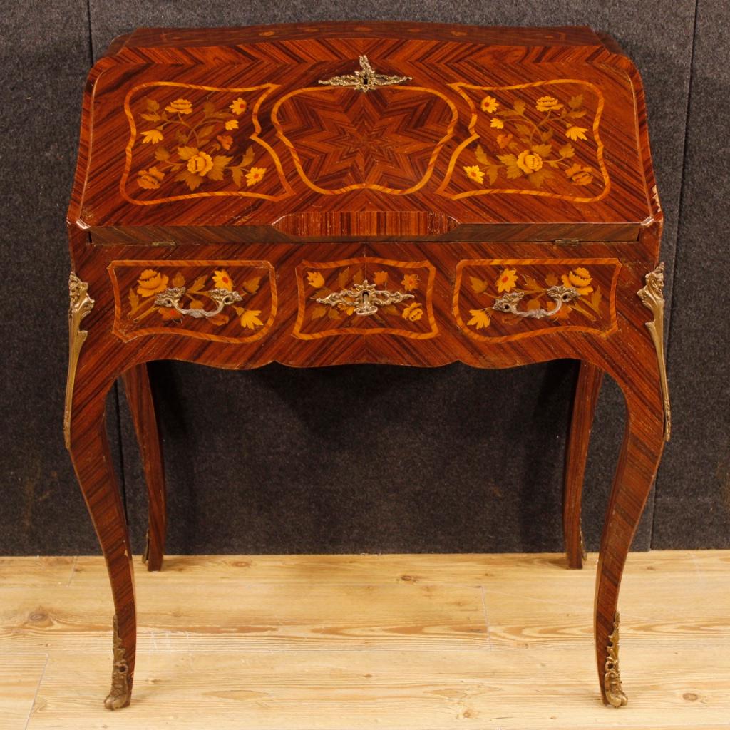 French bureau from 20th century. Furniture with high leg, pleasantly inlaid with floral decorations in rosewood, palisander, mahogany, maple, tulipwood and fruitwood. Bureau finished for the center, adorned with decorations in gilded and chiseled