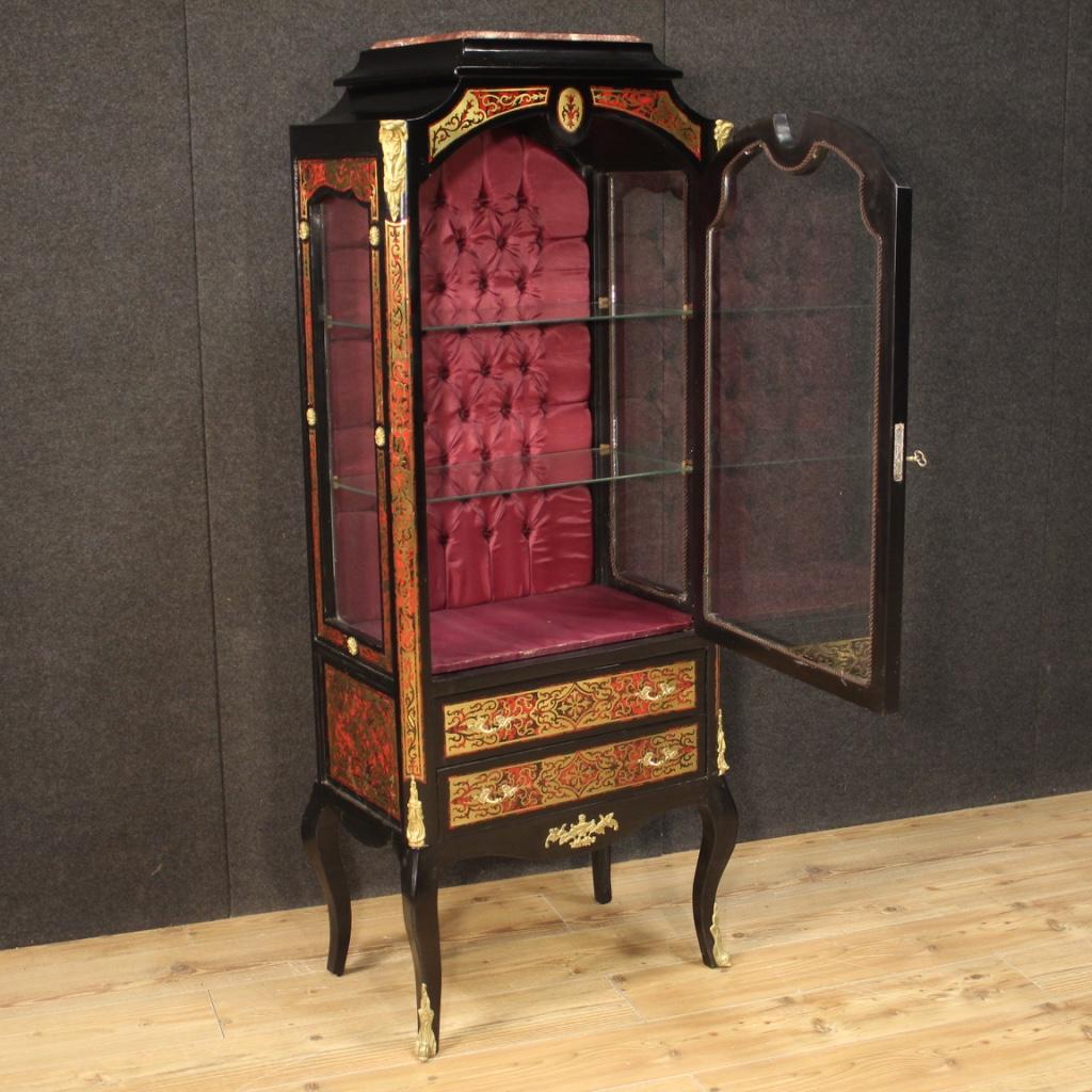 French showcase from the second half of the 20th century. Boulle Napoleon III style furniture in ebonized wood, inlaid with brass and fake tortoise shell. Display cabinet equipped with a door and two external drawers of good capacity. Interior with