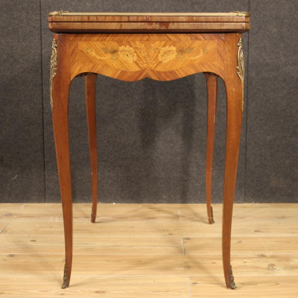 French game table from 20th century. Furniture adorned with floral inlay in mahogany, walnut, maple and fruitwood. Opening table that offers, once opened, a top covered in fabric of good size and service (see photo). Fabric in good condition with