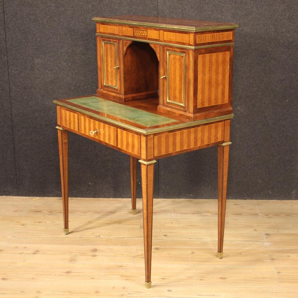 Small French writing desk of the 20th century. Elegant Louis XVI style furniture nicely inlaid in mahogany, maple, walnut, rosewood and fruitwood. Double-body desk with a front drawer and two doors at the top. Top covered in chiseled and gilded faux