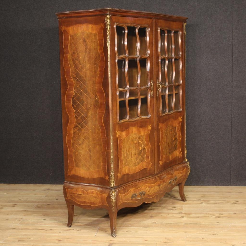 French showcase from the mid-20th century. Moved and rounded Napoleon III style furniture richly adorned with gilded and chiseled brass, inlaid with walnut, mahogany, maple, beech, burl and fruitwood. Showcase equipped with two doors with recessed