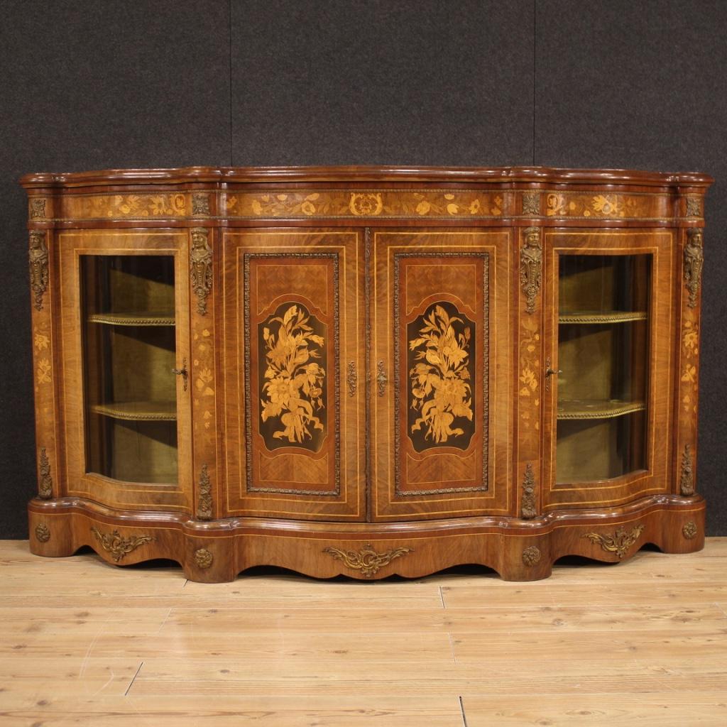 French sideboard from the mid-20th century. Moved and rounded furniture, richly inlaid and adorned with bronze and gilded and chiseled brass, in Napoleon III style. Oversized and impactful cabinet inlaid in walnut, mahogany, maple and fruitwood.