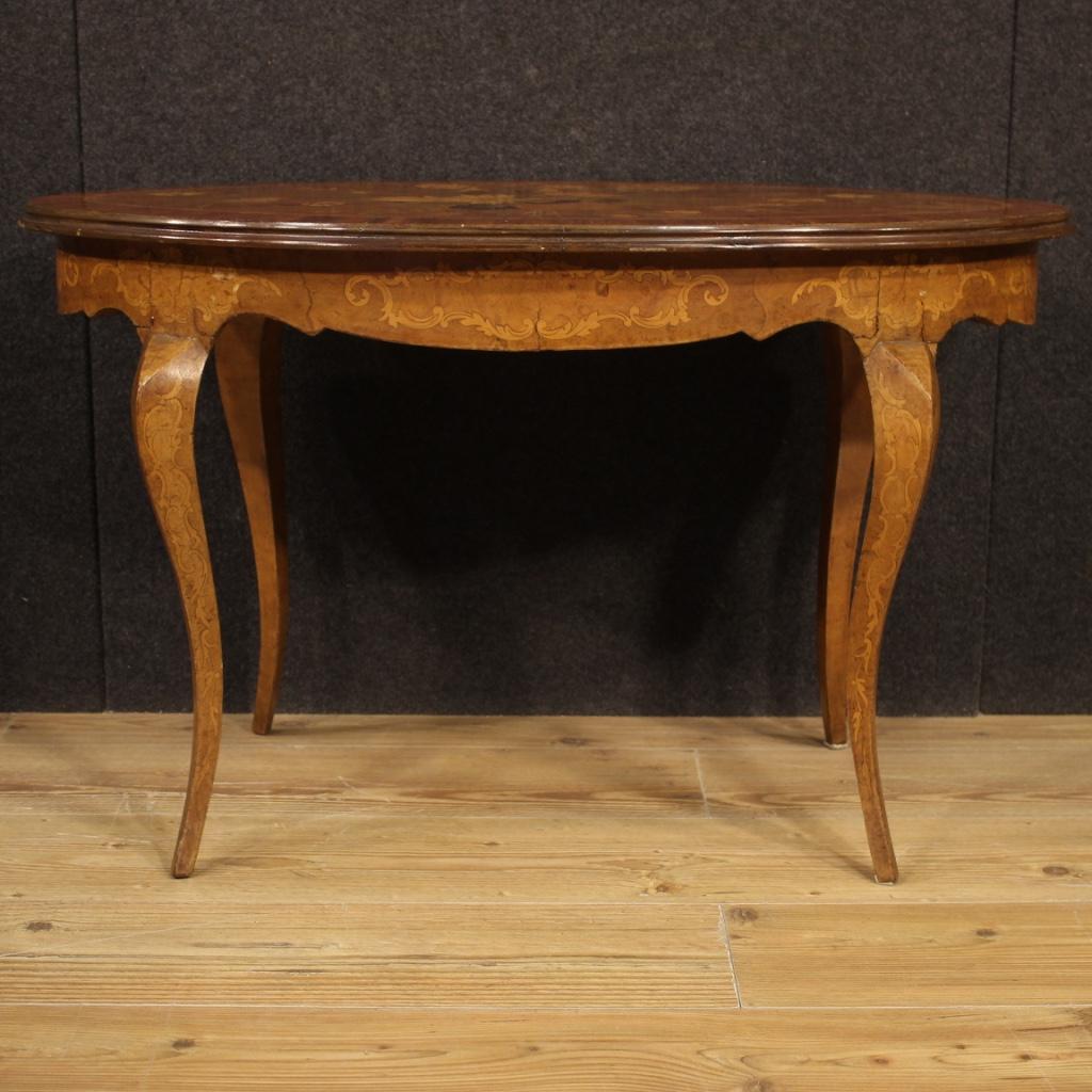 Italian coffee table from 20th century. Furniture richly inlaid in walnut, palisander, maple, rosewood, burl and fruitwood. Oval coffee table of small size, it can be easily placed in different points of the house. Movable leg furniture with wooden