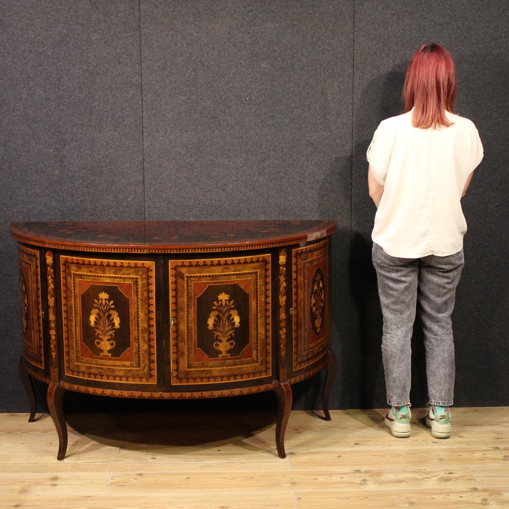 Italian half moon sideboard from the mid-20th century. Beautifully lined and pleasantly inlaid furniture in walnut, burl, rosewood, maple, mahogany, cherry and fruitwood. Four-door sideboard offering three internal compartments. Large central