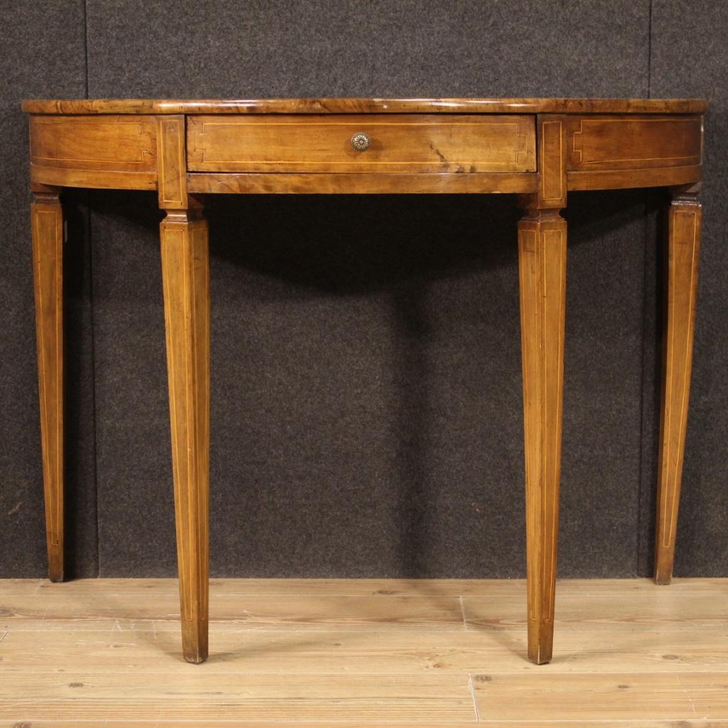 Italian console of the mid-twentieth century. Louis XVI style demilune furniture carved and inlaid in walnut, maple and fruitwood. Table equipped with a front drawer of good capacity and wooden top in character with various scratches / marks (see