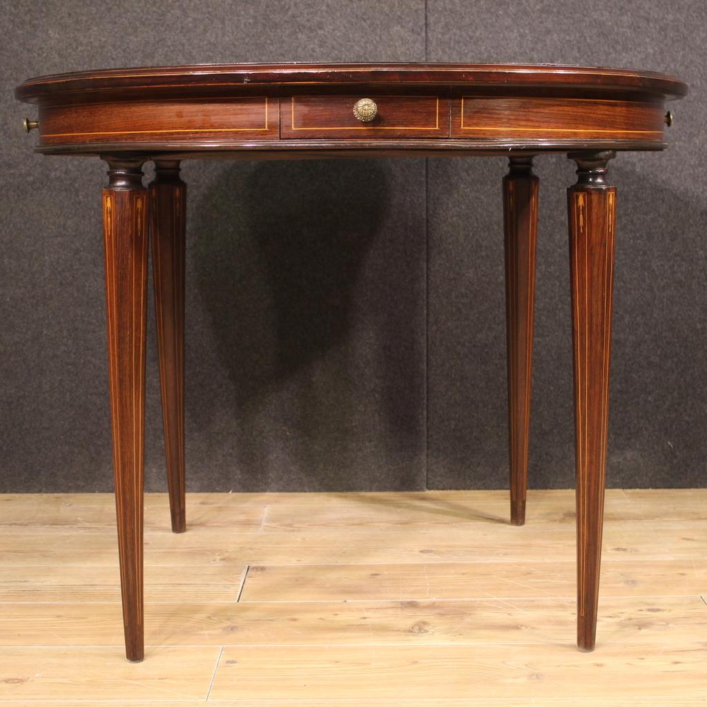 Elegant mid-20th century Italian round table. Furniture of beautiful line finely inlaid in palisander, maple, beech and fruitwood. Game table equipped with 4 drawers of moderate capacity and wooden top in character. The top has some small signs of