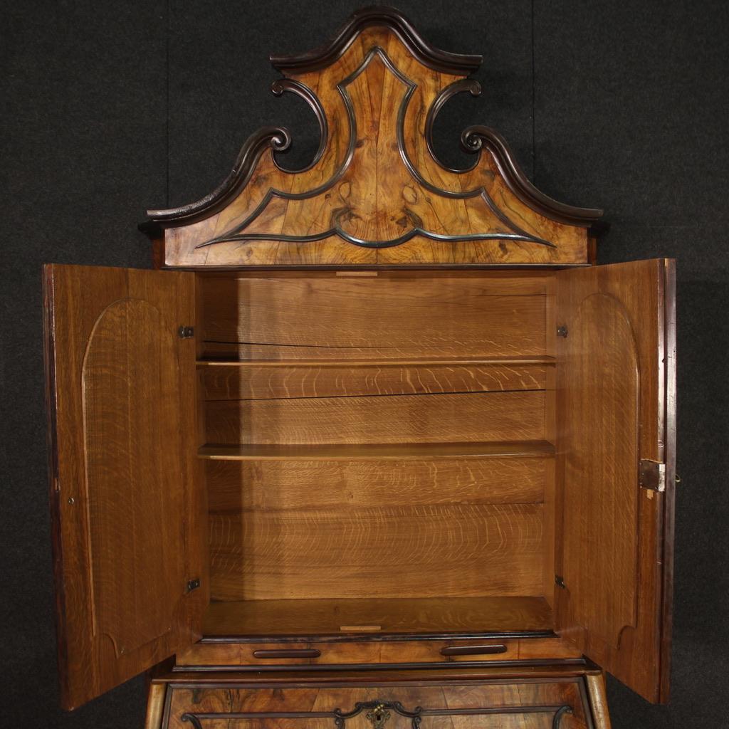 Elegant mid-20th century Lombard trumeau. Double body cabinet in Baroque style carved in walnut, ebonized wood and fruitwood. Trumeau for living room or study equipped with three drawers and fall-front in the lower body. Bureau that offers inside