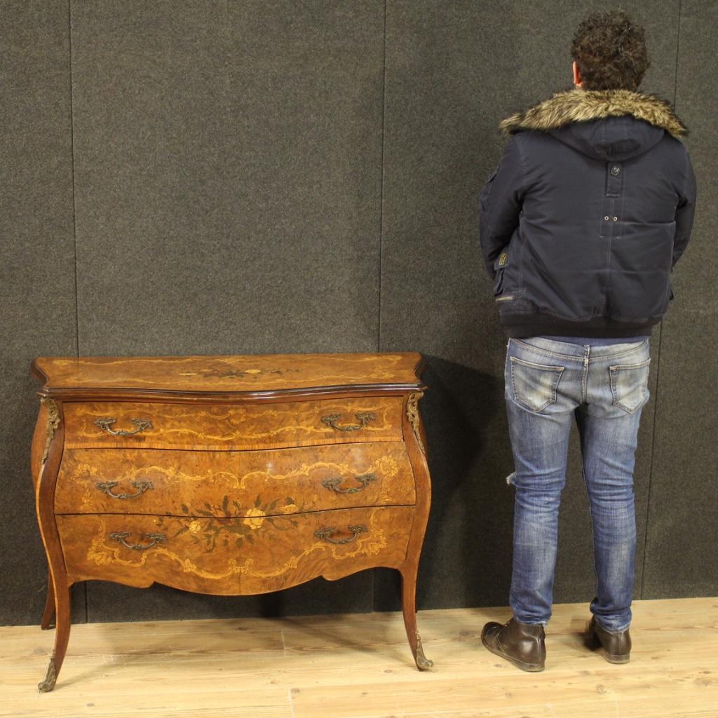 Italian commode of the 20th century. Furniture richly inlaid in walnut, burl, maple, rosewood, bois de rose, beech and fruitwood. Moved and rounded chest of drawers equipped with three front drawers of good capacity and service. Wooden top in