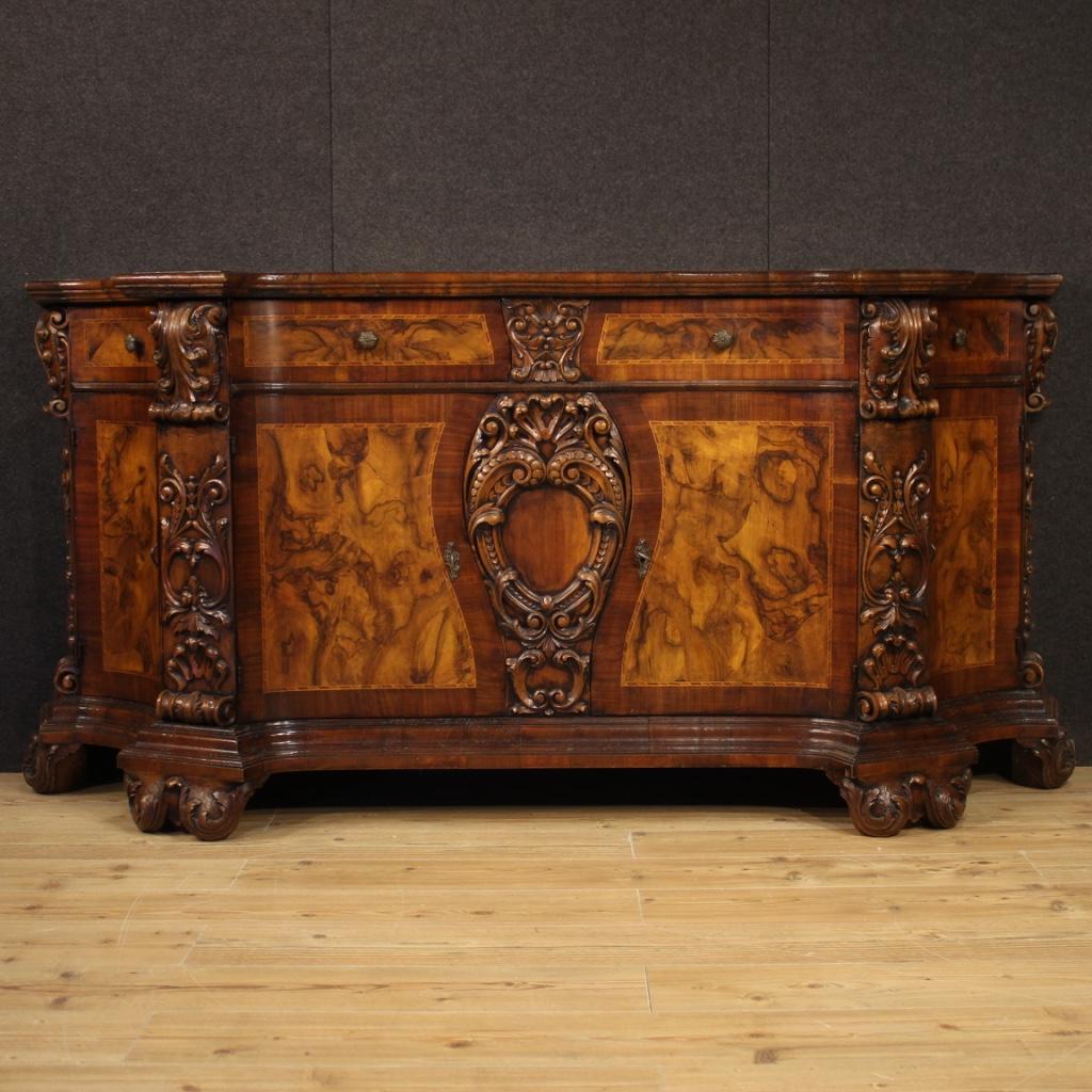 Italian Renaissance sideboard from the mid-20th century. Furniture richly carved and inlaid in walnut, beech, burl, maple and fruitwood of exceptional quality and impact. Sideboard with four doors and two front drawers, of excellent capacity. Wooden