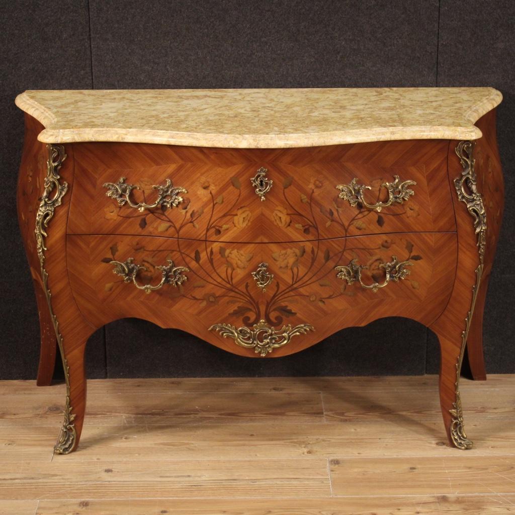 French chest of drawers from 20th century. Moved and rounded furniture, veneered and inlaid with rosewood, maple, mahogany and fruitwood with floral decorations on the front and sides (see photo). Chest of drawers equipped with two large front