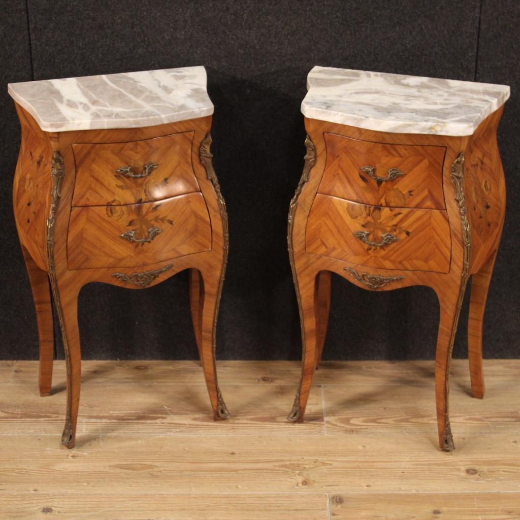 Pair of French bedside tables from the 20th century. Furniture nicely inlaid with floral decorations in rosewood and fruitwood. High-leg bedside tables adorned with gilded and chiseled bronze, equipped with two drawers each of discreet capacity. Top