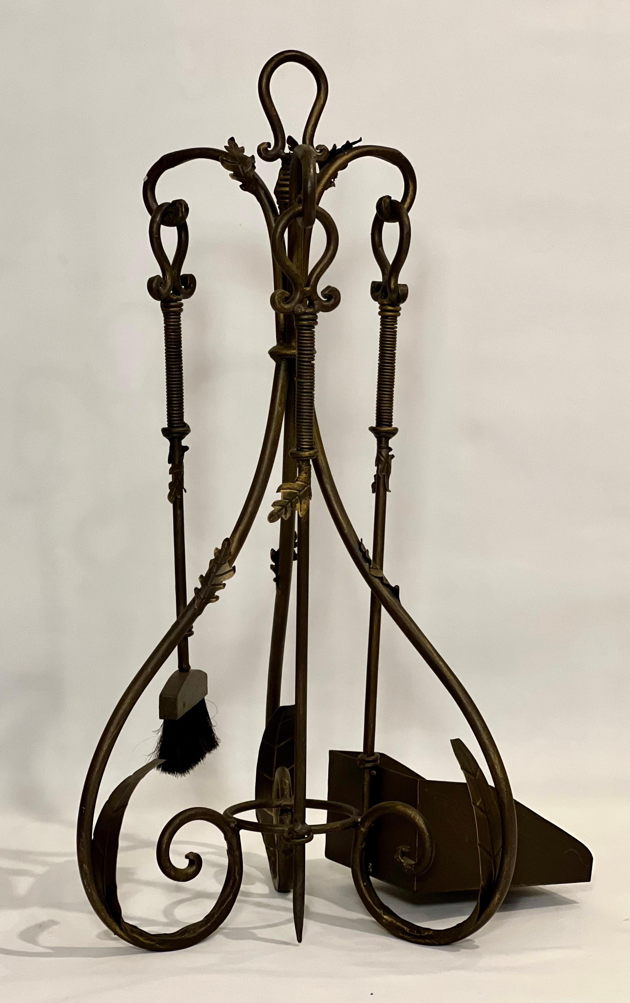 Impressionante set di attrezzi da camino in ferro vintage con una grande pala, una spazzola e un attizzatoio.  Il set è caratterizzato da grandi volute con dettagli a foglia in finitura bronzo.  Un set notevole in condizioni di pulizia e con minimi