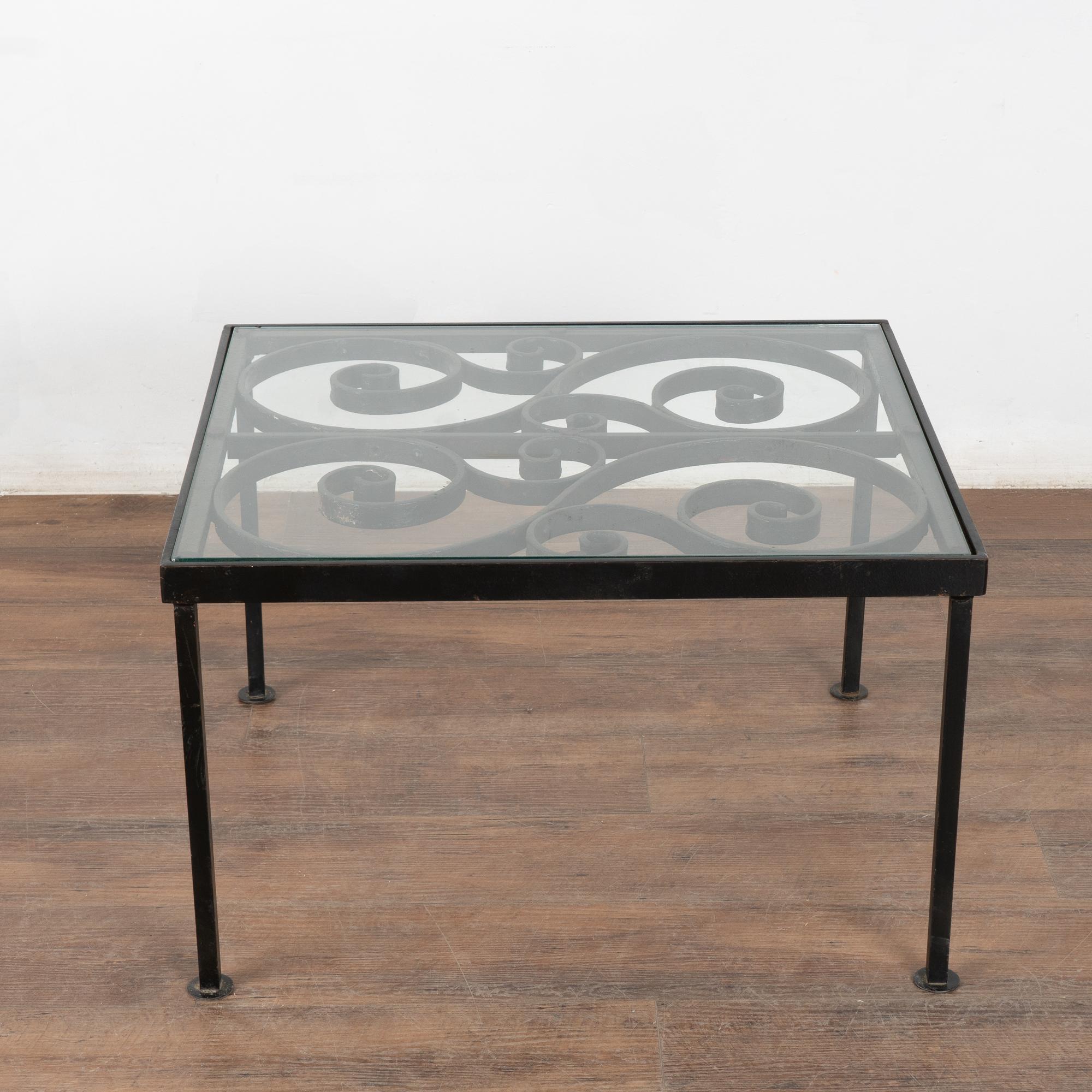 The decorative top of this unique table is made from an old fence. The iron base was created to hold the top which is covered with a heavy glass top. Fun and functional, this will make a one of a kind accent piece or small coffee table.    

With