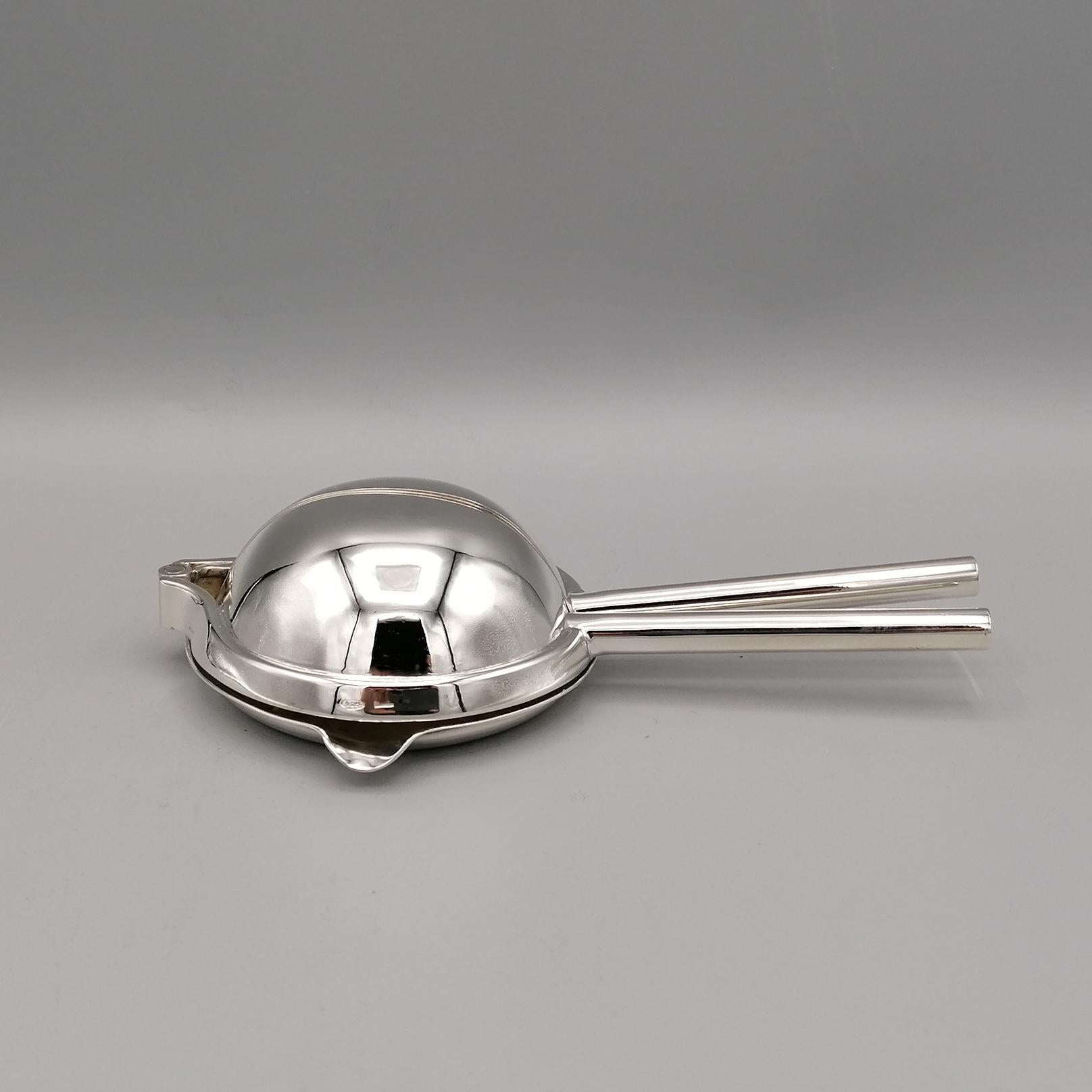 Squeezer in sterling silver.
The juicer is divided into two hinged parts. 
It opens horizontally allowing you to place the slice of lemon or orange to be subsequently pressed to make sure that the juice comes out of the special spout. 
The body