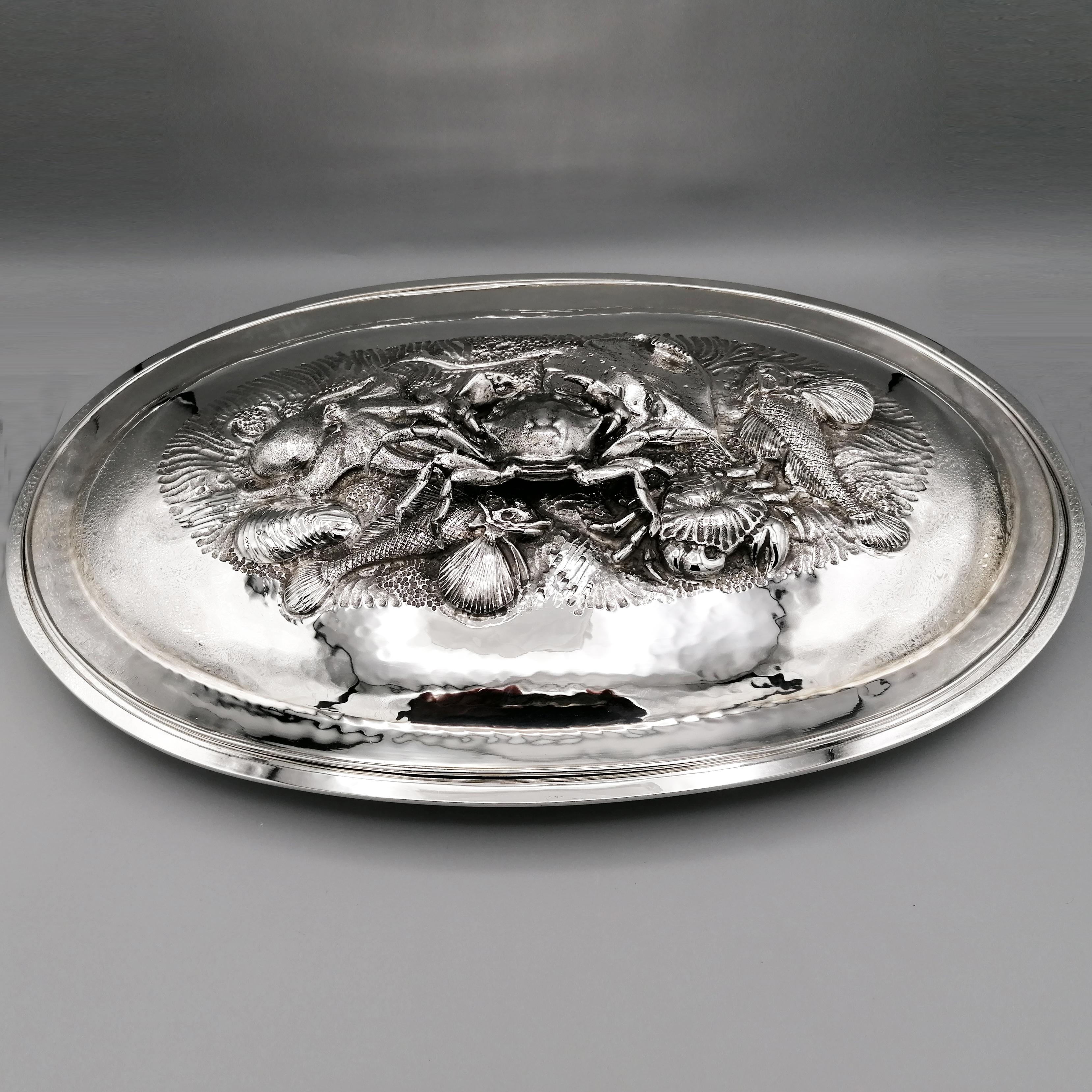 Serving plate for fish and shellfish in 800 solid silver.
The plate, completely handmade, is oval and has been completely hammered by hand.
The lid, in addition to being hammered as well, has been embossed and chiseled with marine motifs in their