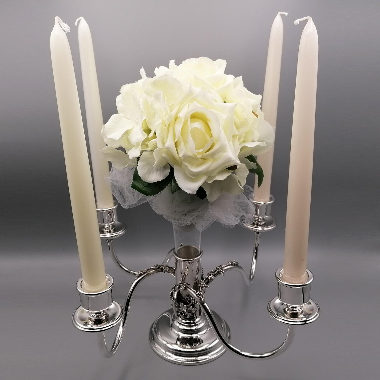 Gourmand et élégant Candélabre - Centre de table avec 4 lumières en argent massif 800. La base est ronde et la tige centrale est le siège d'un porte-fleurs en verre. De la tige centrale partent 4 bras à section ronde et lisse qui se terminent par le