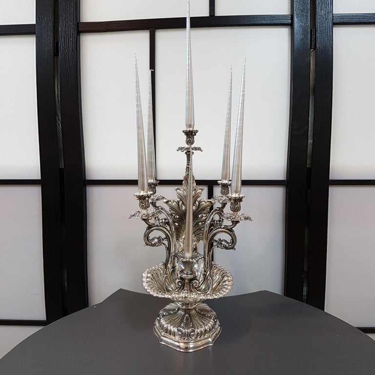 Candelabra-centerpiece in 800 solid silver.
Resting on a shell and round base, shaped and finely embossed and chiseled, the candelabra has 6 lights.
The casting arms are engraved and chiseled and above them the small dishes and the candle holder