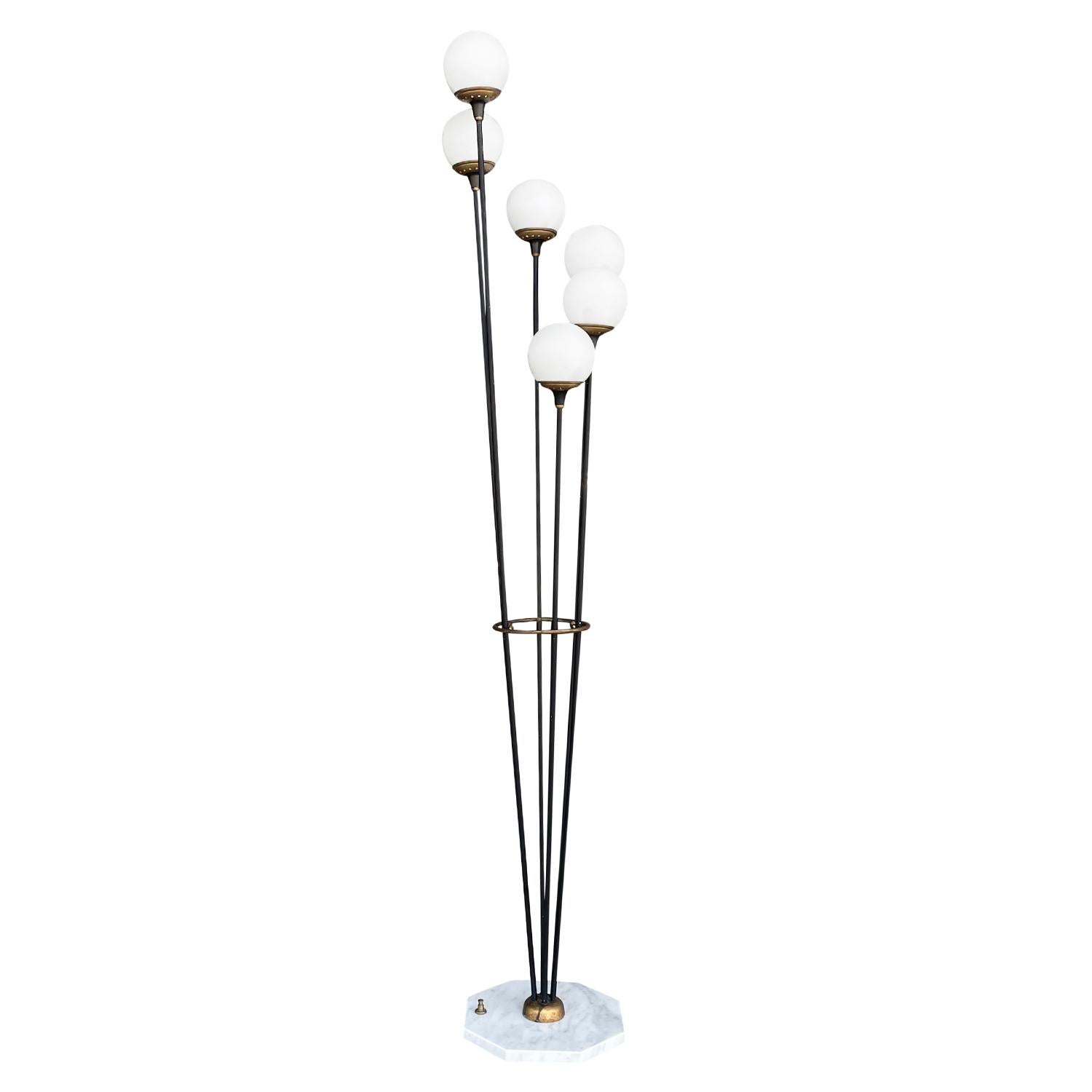 A vintage Mid-Century Modern Italian floor lamp made of hand crafted metal and brass, designed and produced by Stilnovo, in good condition. The floor lamp is composed with six round brass, frosted opaline glass shades, each of the glass lights is