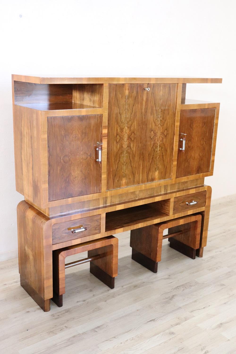 Beautiful and rare Italian art deco bar cabinet in walnut veener, 1940s. The side doors have internal support for smaller bottles. In the central part it is possible to place the larger bottles. Two practical drawers for storing tools necessary for