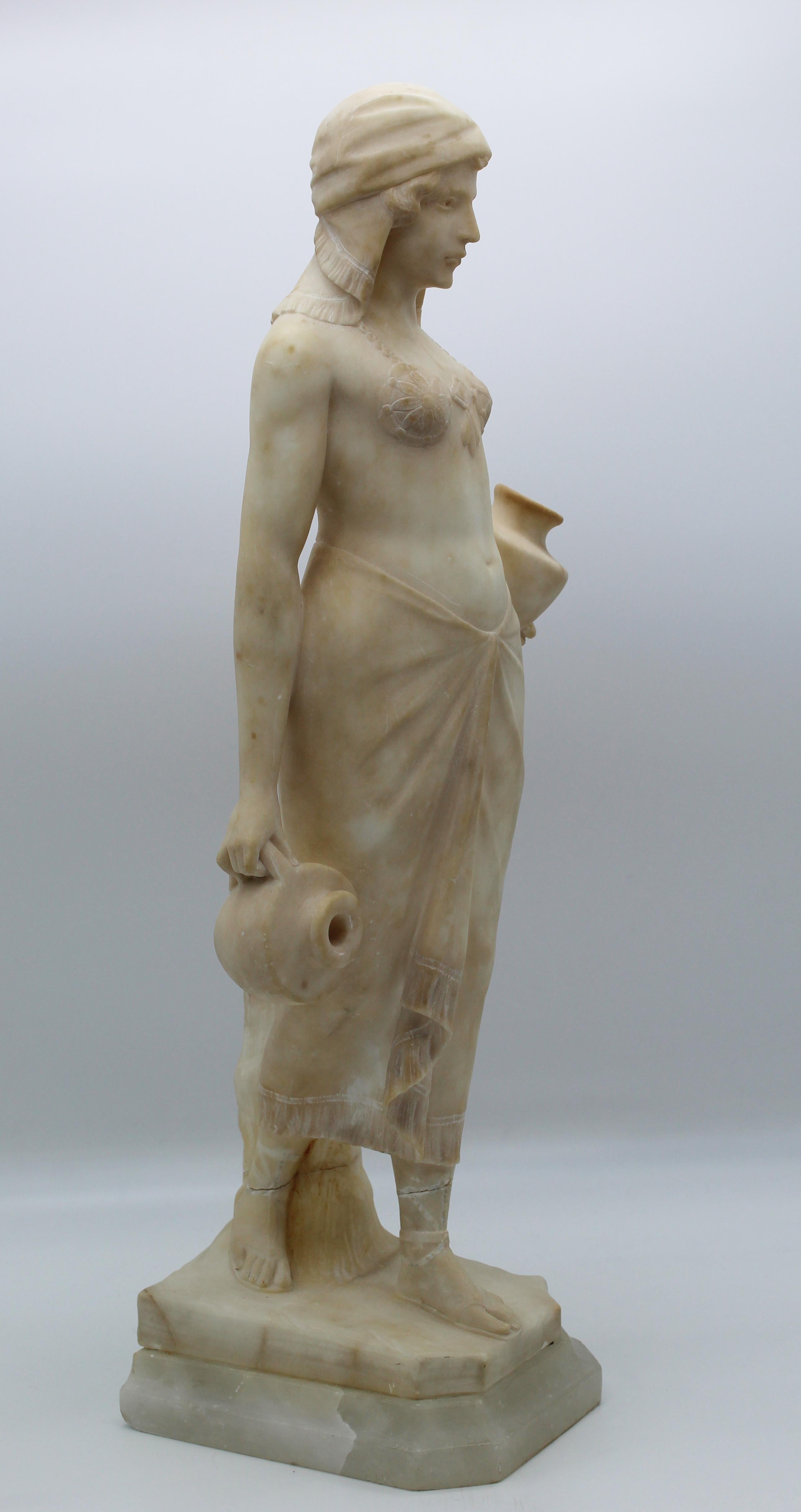 A very beautiful and impressive sculpture portraying a woman that is carryng water; the style and the details of the sculpture is a classical example of art Déco, some decorations and some dressing accents show influences of the exotic area as an