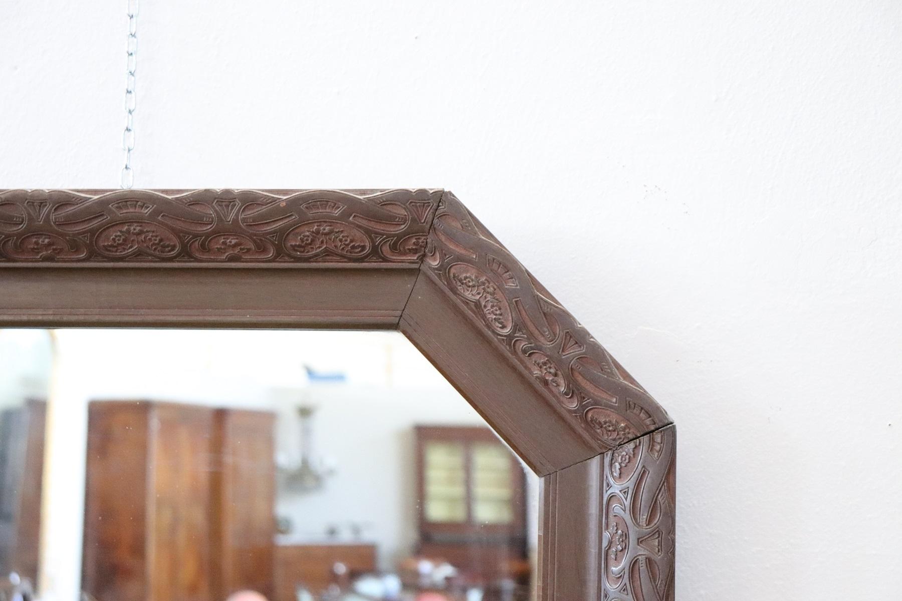 Elegant Italian Art Nouveau wall mirror in finely carved walnut wood. Beautiful decoration carved in wood with flowers curls and scrolls. Used condition small flaw in the corner.