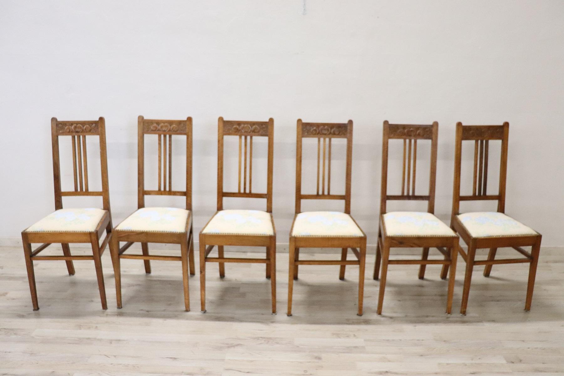 Series of six refined Art Nouveau Italian walnut wood chairs. Very simple and linear with floral decoration carved in the wood on the back. Perfect for a dining table. Beautiful chairs ready to be placed in your beautiful home.