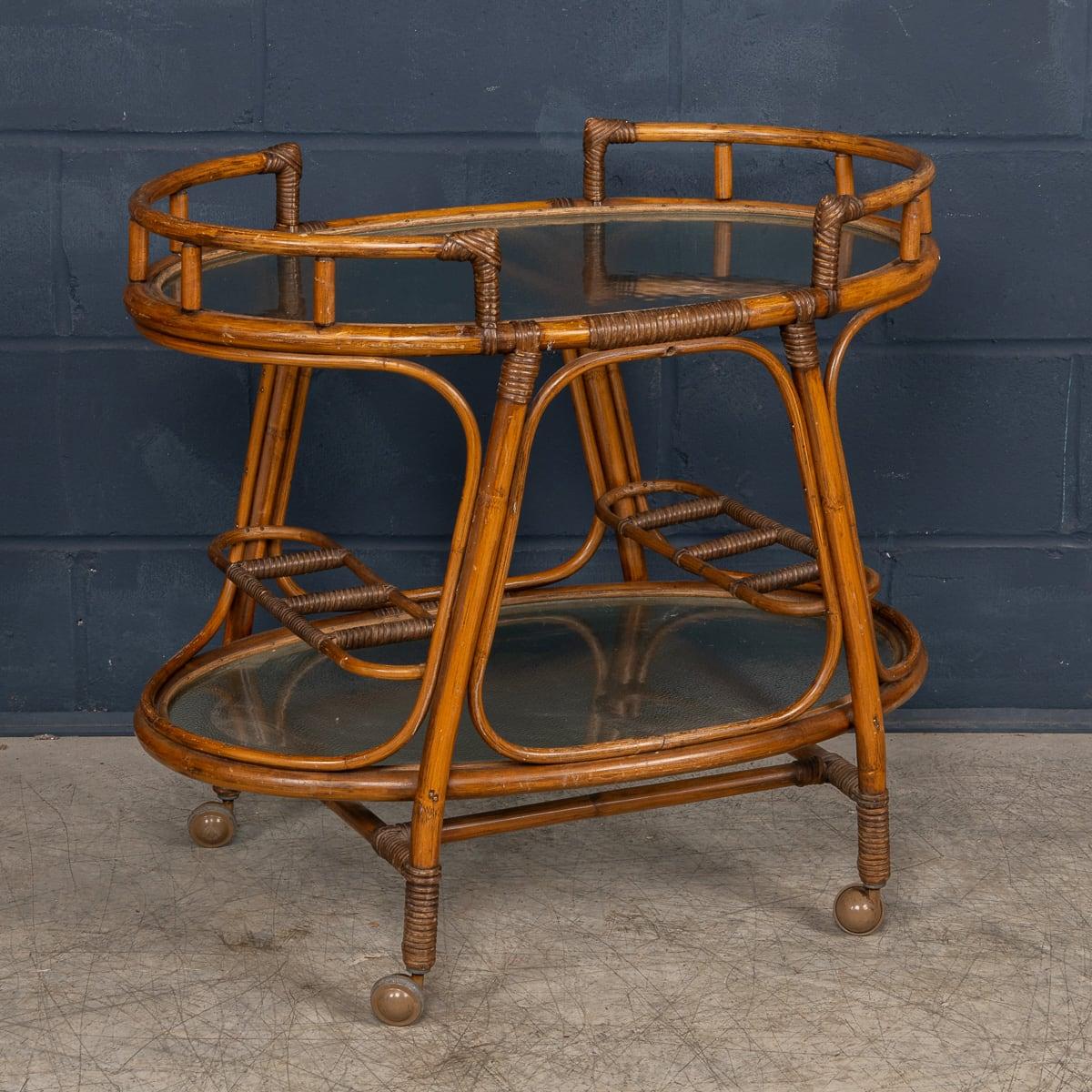 Un élégant chariot à boissons en bambou, fabriqué en Italie dans les années 1970. Il incarne parfaitement la sophistication du milieu du siècle avec une touche rustique. Le cadre en bambou foncé dégage une chaleur et une élégance naturelle, tandis
