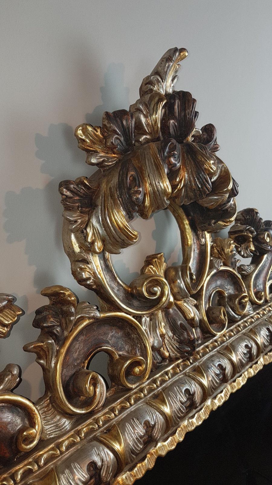 Beautiful elegant large mirror in perfect Baroque style wood finely and richly carved with swirls of great refinement decorated in gold and silver leaf.