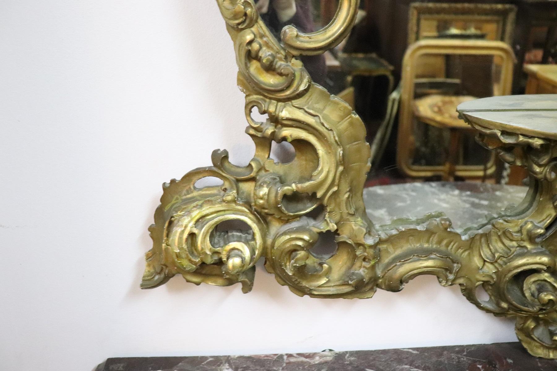 Luxury Italian Baroque style carved wood wall mirror 1950s with refined decoration in gilded wood. Very rich work in baroque style with curls and swirls. This mirror is perfect for a refined and elegant home.
 